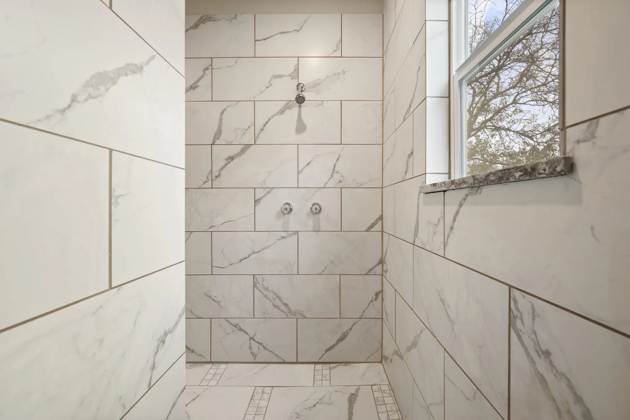 Bathroom with a tile shower and healthy amount of natural light
