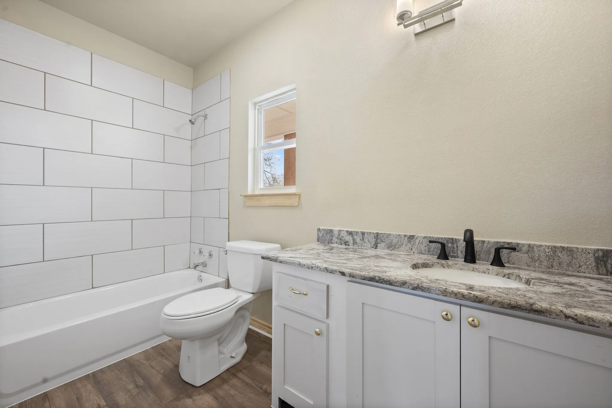 Bathroom featuring shower / bathtub combination, vanity, and dark wood-style floors