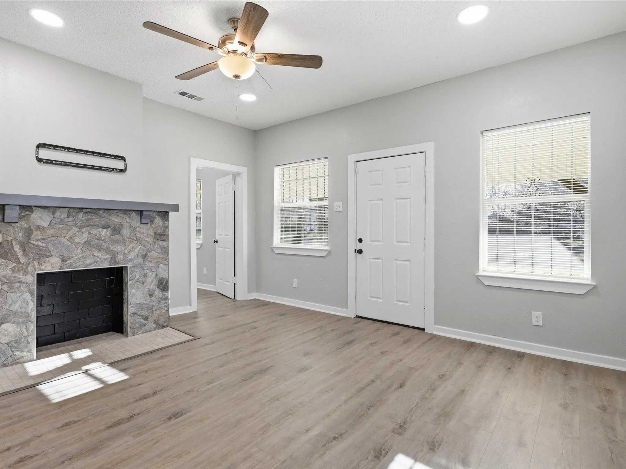 Unfurnished living room with a ceiling fan, light wood-style floors, a fireplace, and recessed lighting
