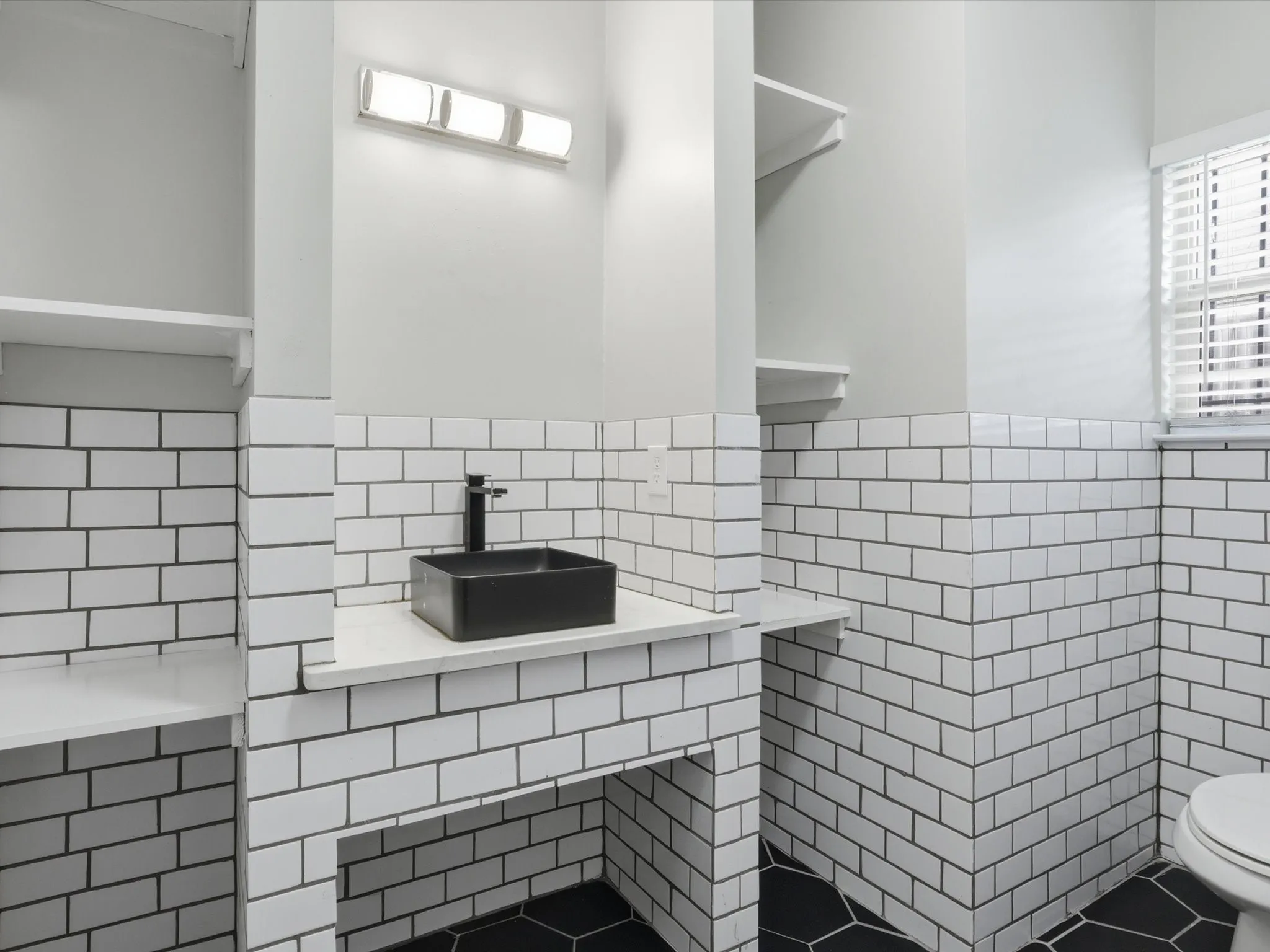 Bathroom with tile walls, vanity, wainscoting, and tile patterned floors
