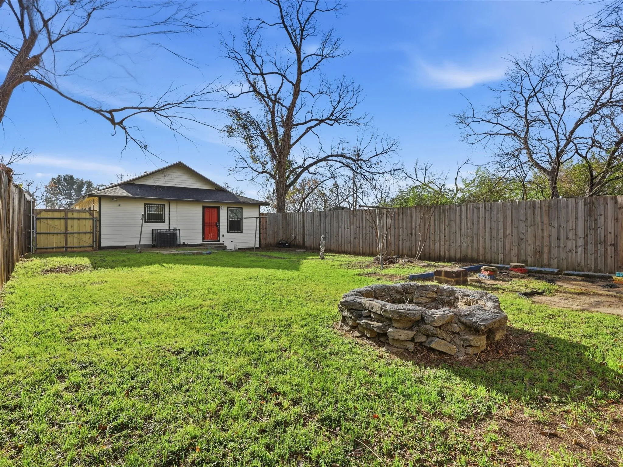 Fenced backyard with a fire pit and a patio area