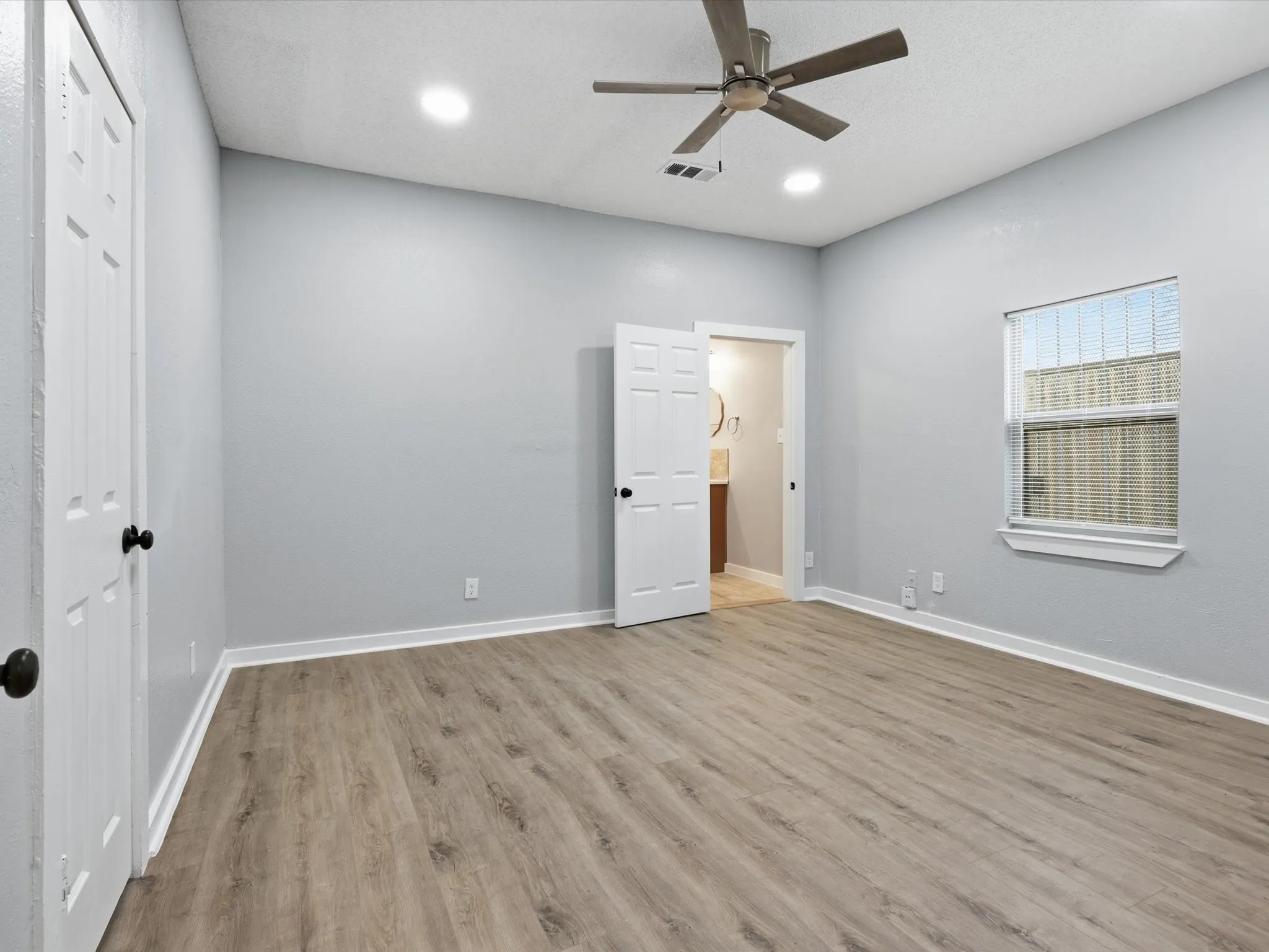 Unfurnished bedroom with light wood-type flooring, a ceiling fan, and recessed lighting
