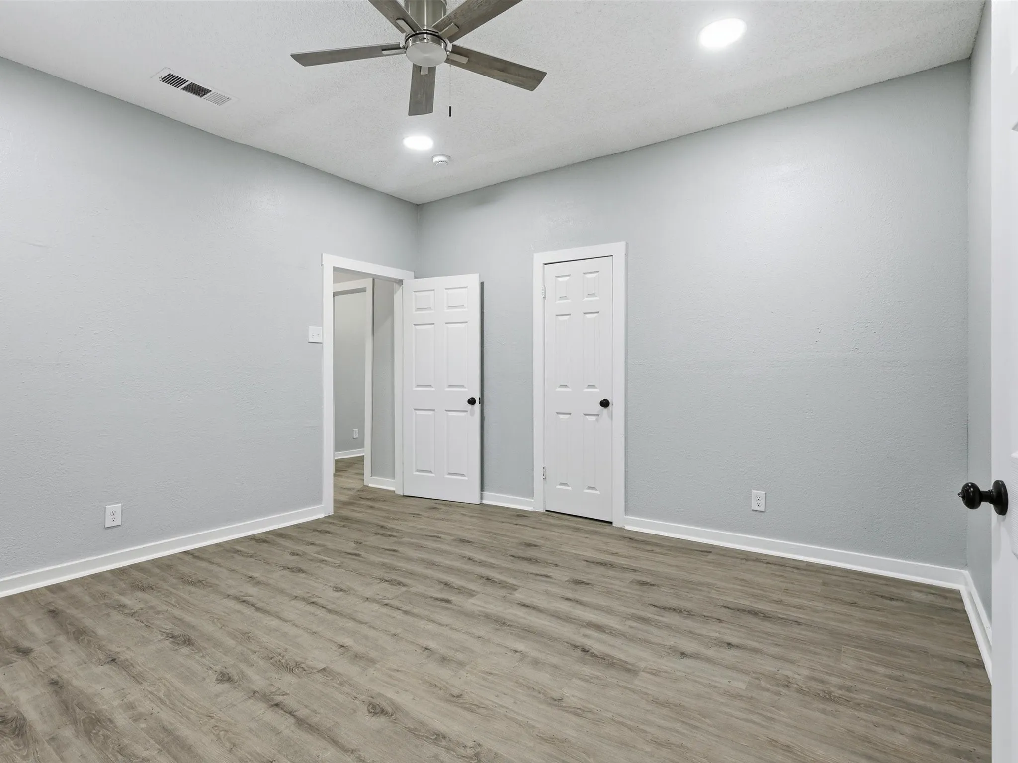 Unfurnished bedroom with a ceiling fan, wood finished floors, and recessed lighting