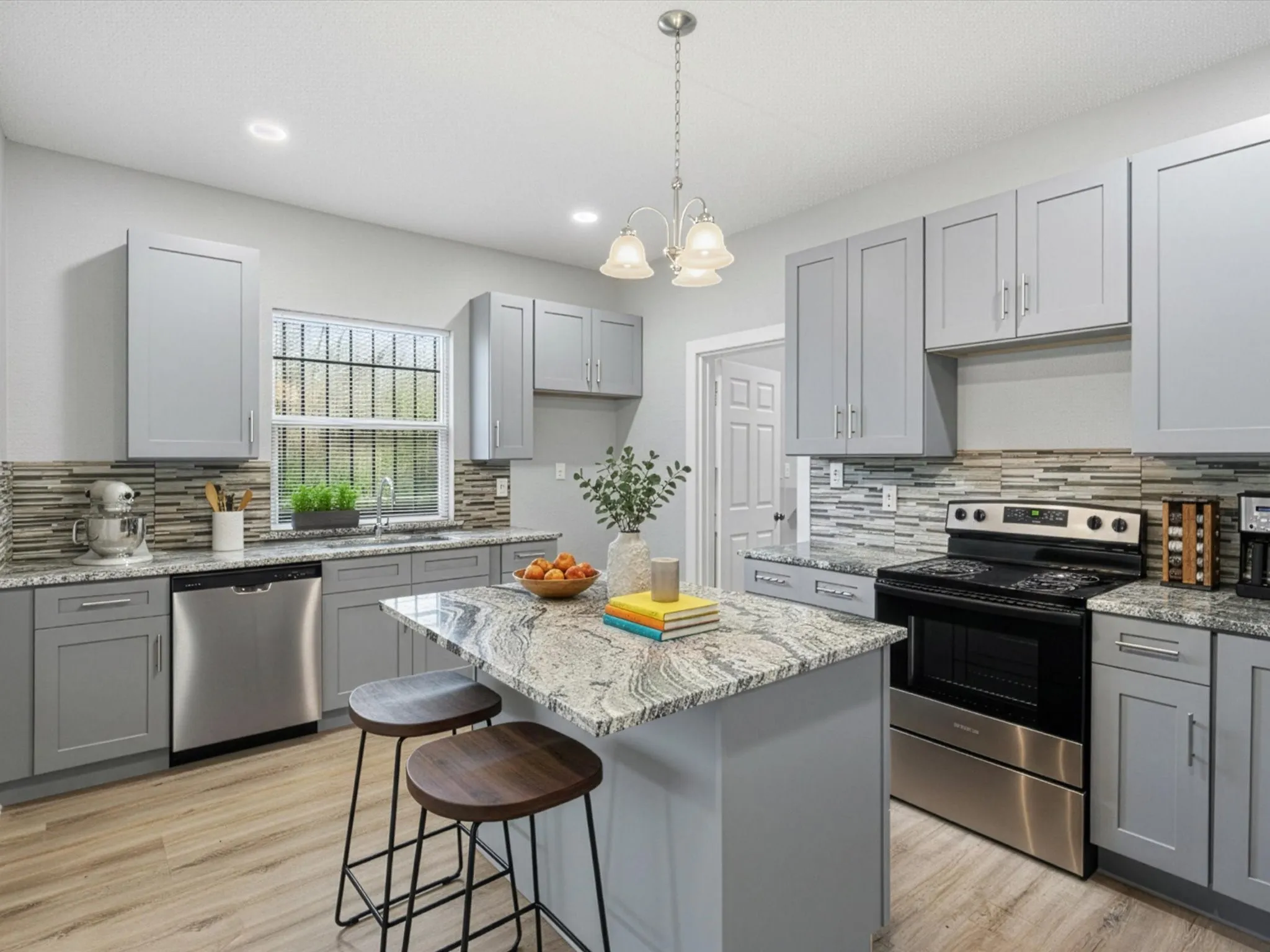Kitchen with gray cabinetry, stainless steel appliances, light stone counters, and light wood-type flooring