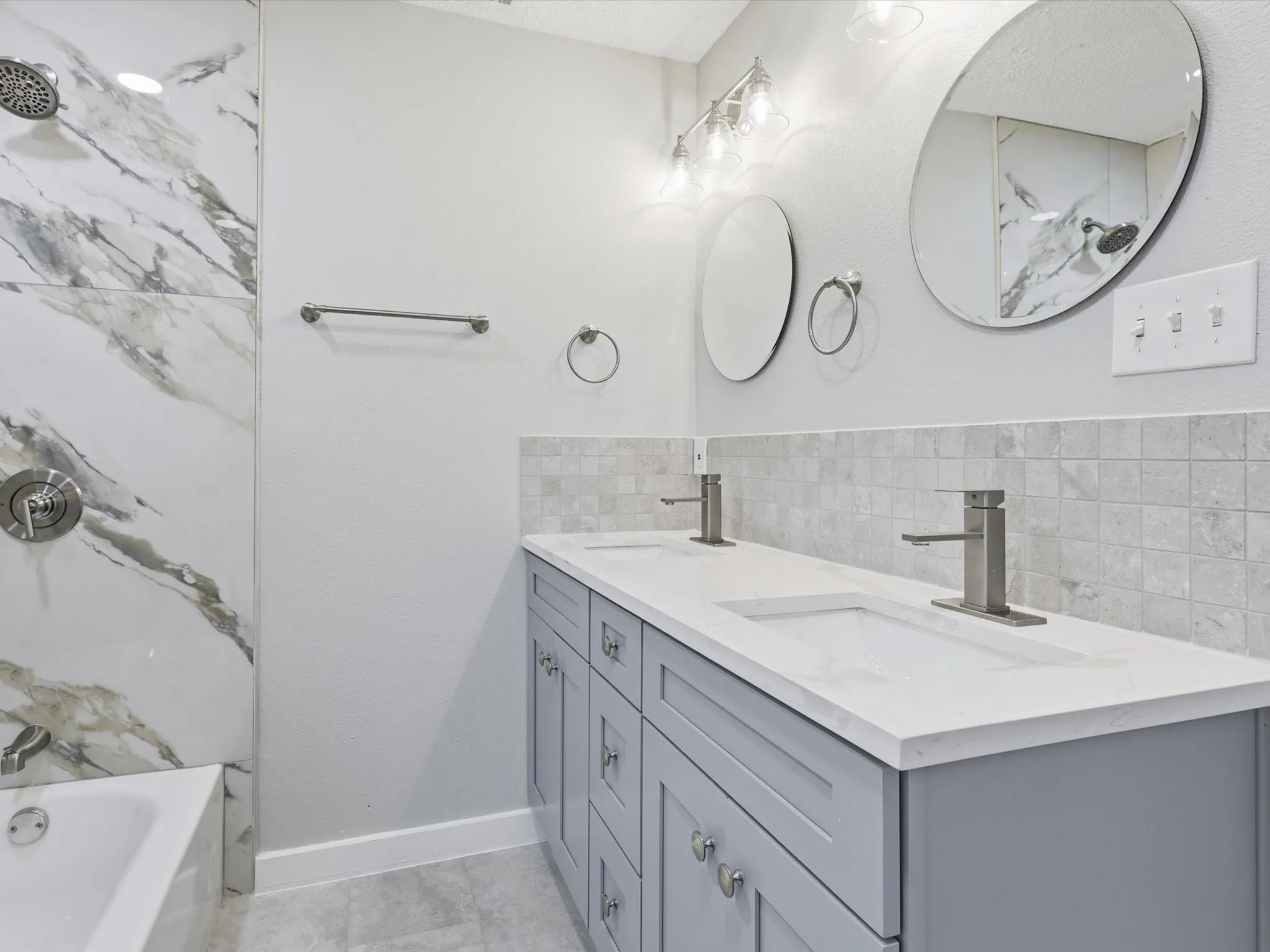 Bathroom featuring double vanity and tub / shower combination