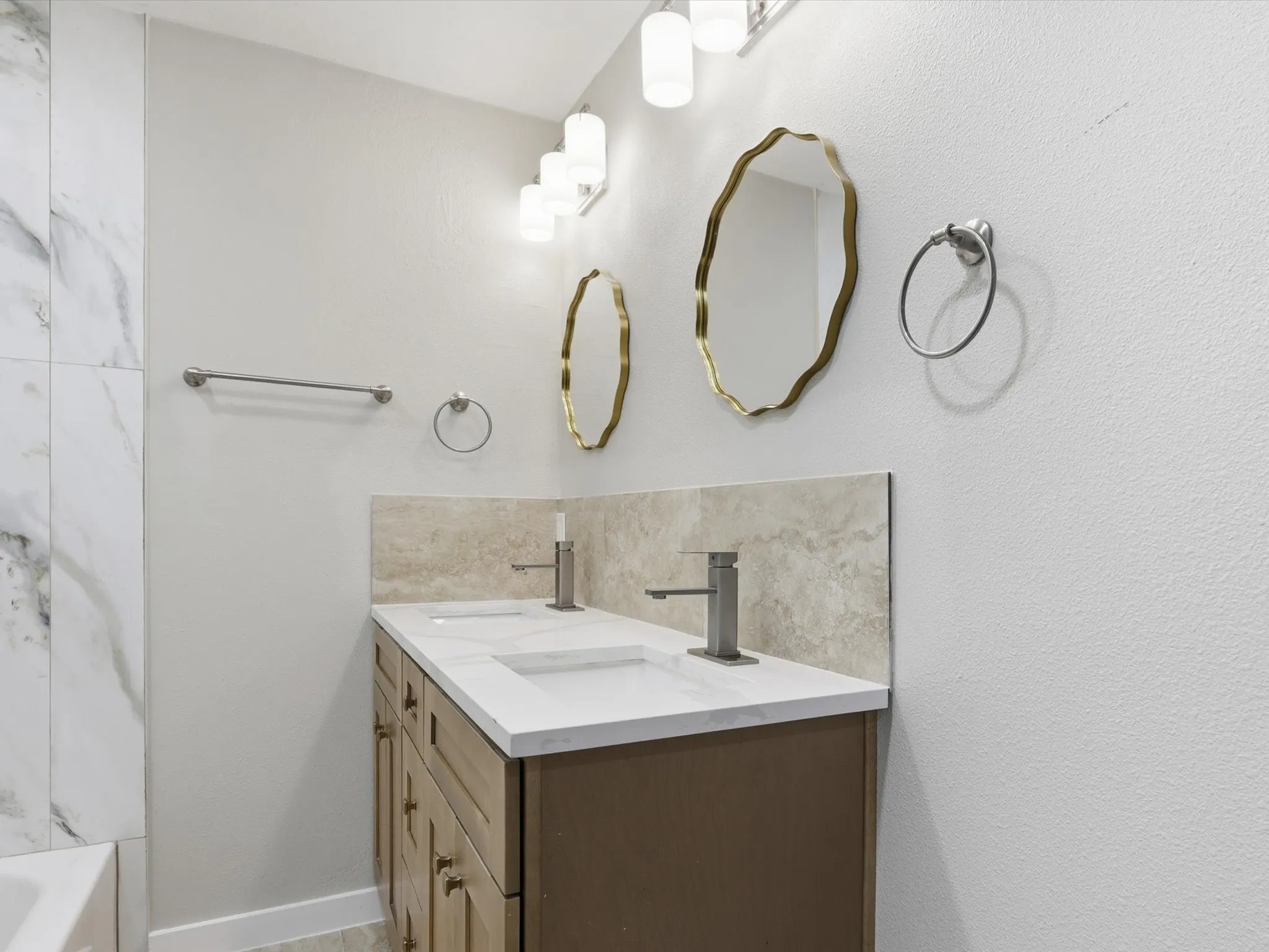 Full bath with double vanity and baseboards