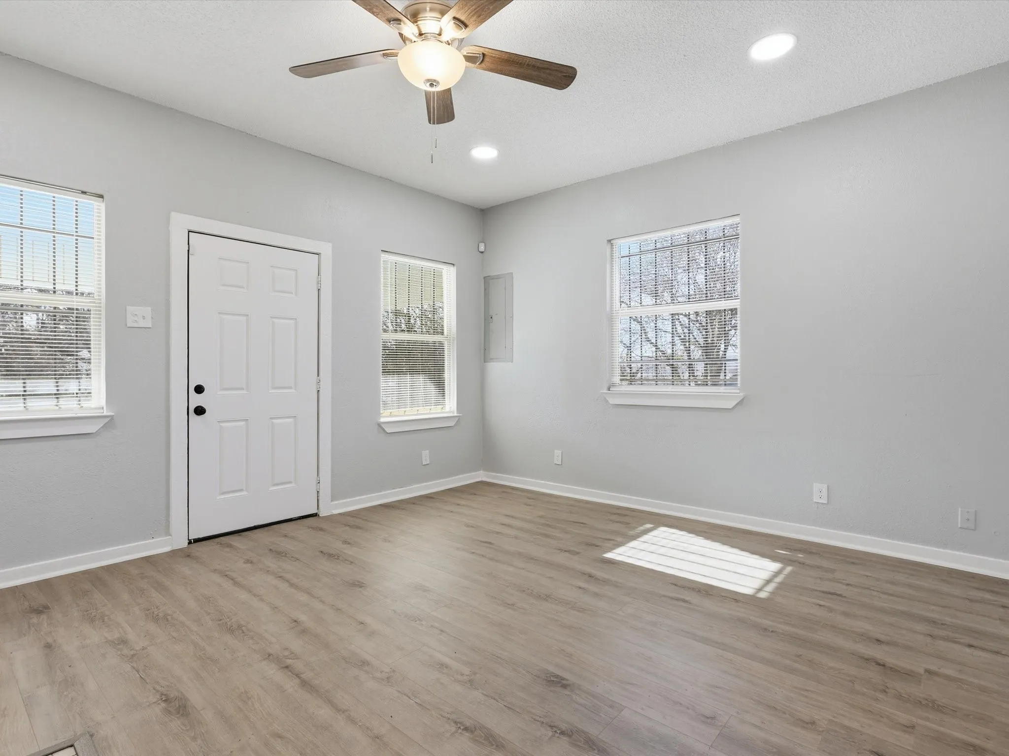 Entryway with healthy amount of natural light, ceiling fan, light wood-style floors, recessed lighting, and a textured ceiling