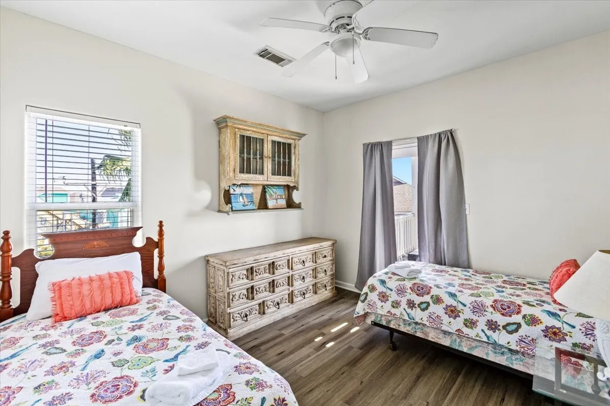 Bedroom featuring dark hardwood / wood-style floors, multiple windows, and ceiling fan