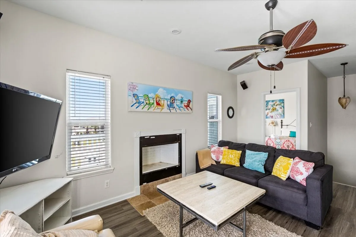Living room with ceiling fan and dark hardwood / wood-style flooring