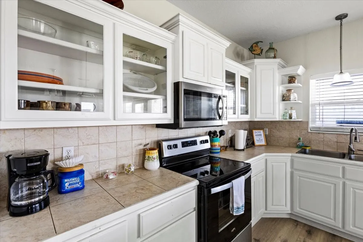 Kitchen featuring light hardwood / wood-style floors, sink, stainless steel appliances, and white cabinets