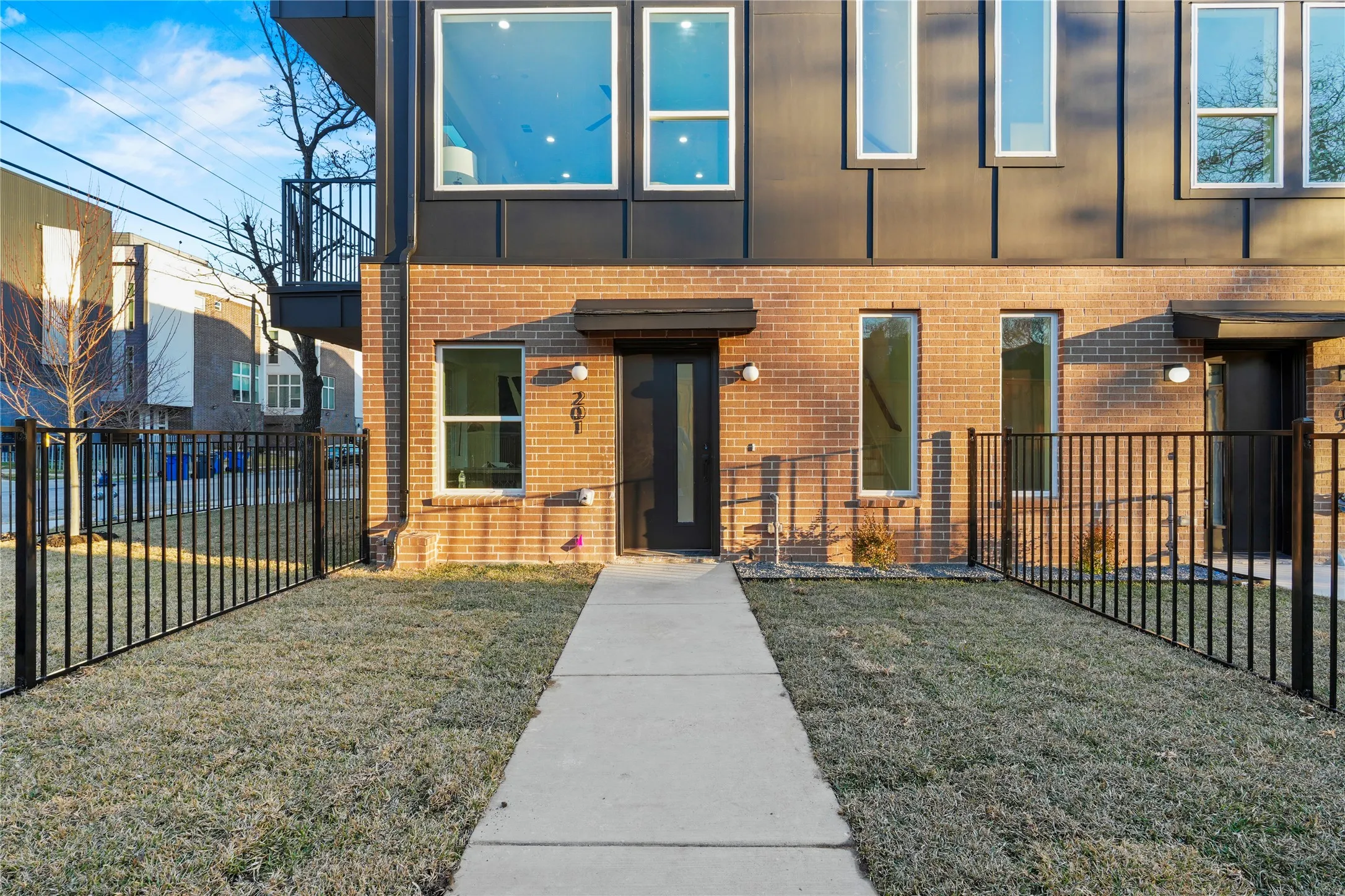 View of front of property with brick siding and a balcony