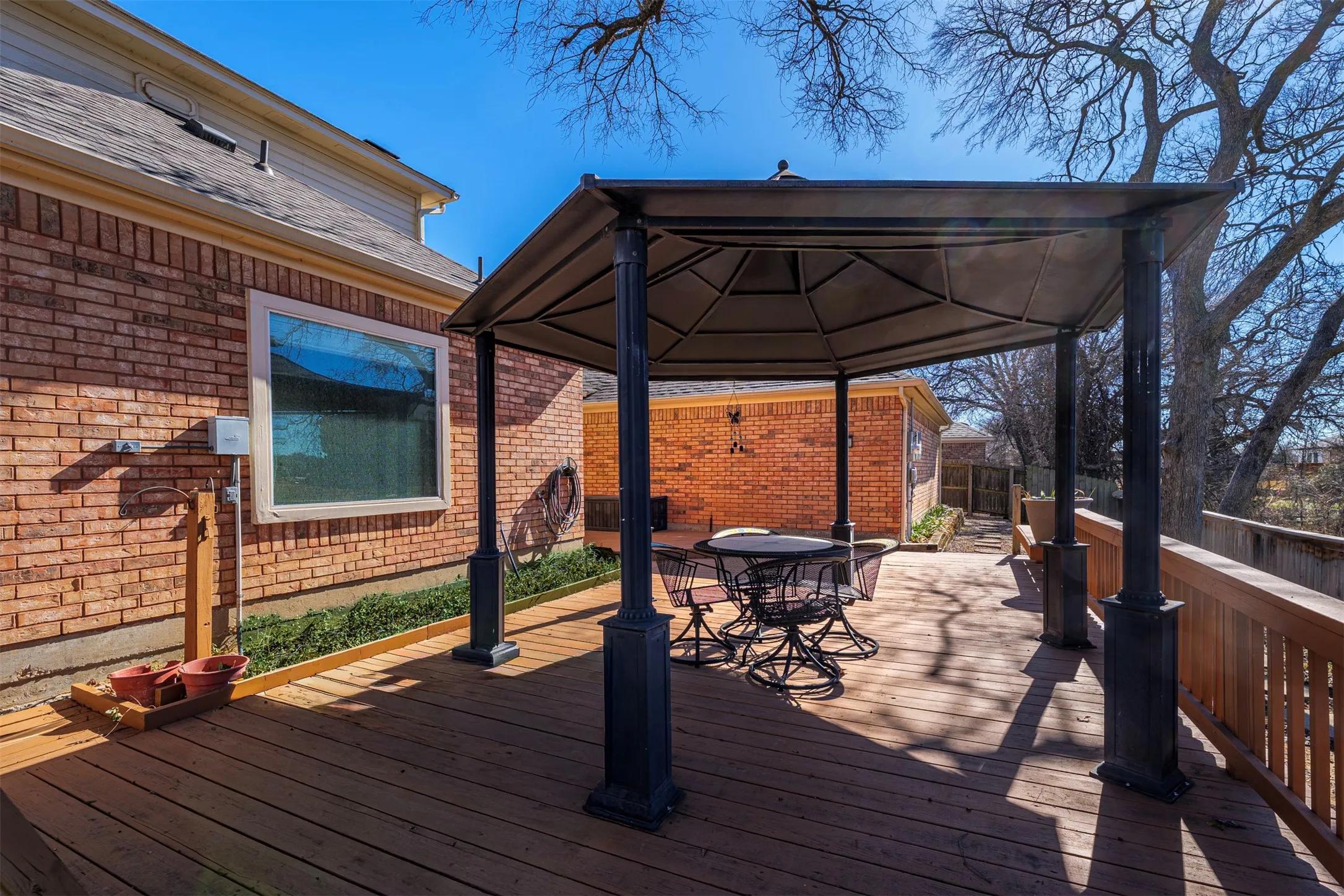 Wooden deck with a gazebo and outdoor dining space