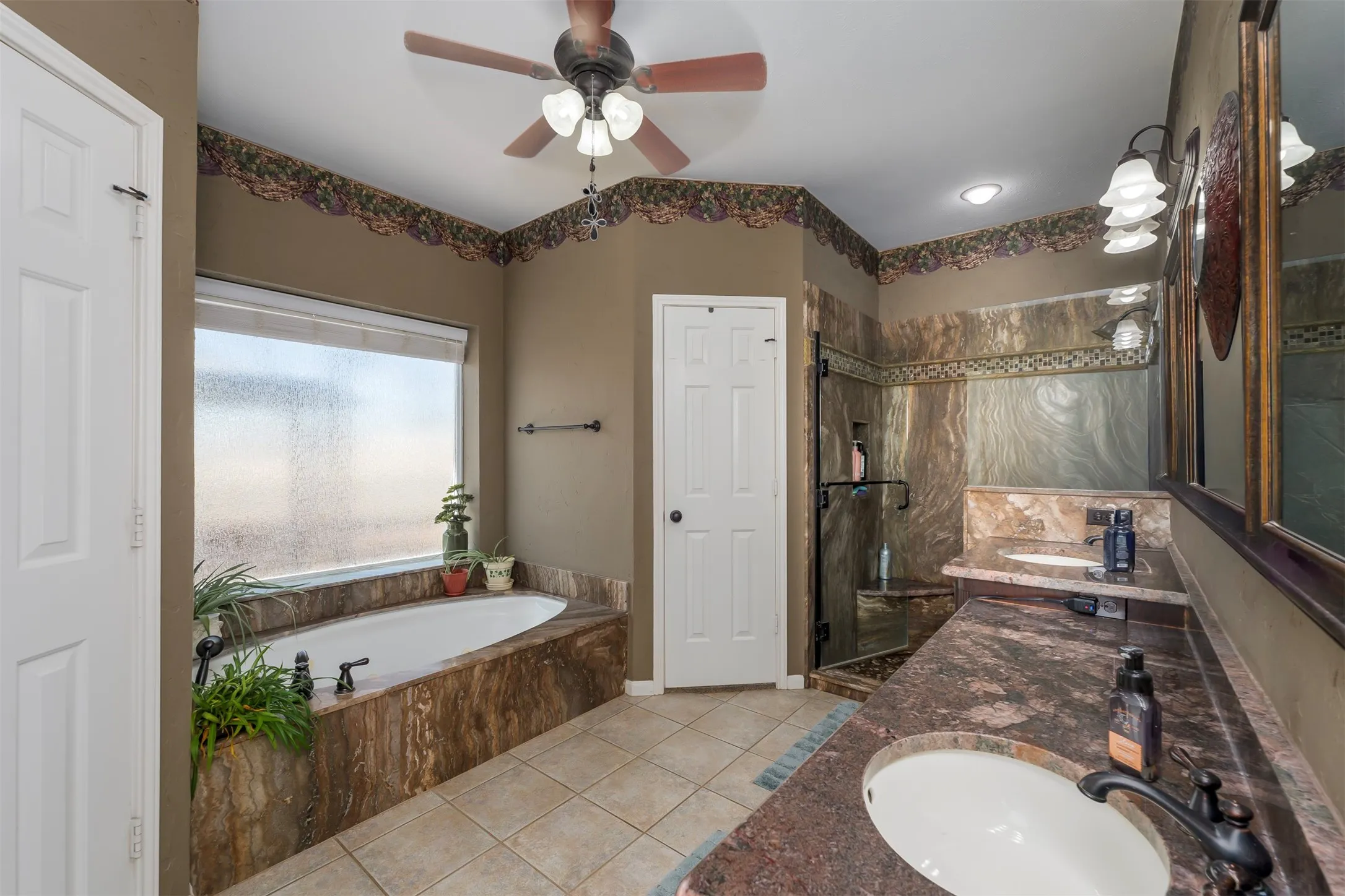 Bathroom with vanity, light tile patterned floors, a garden tub, ceiling fan, and walk in shower