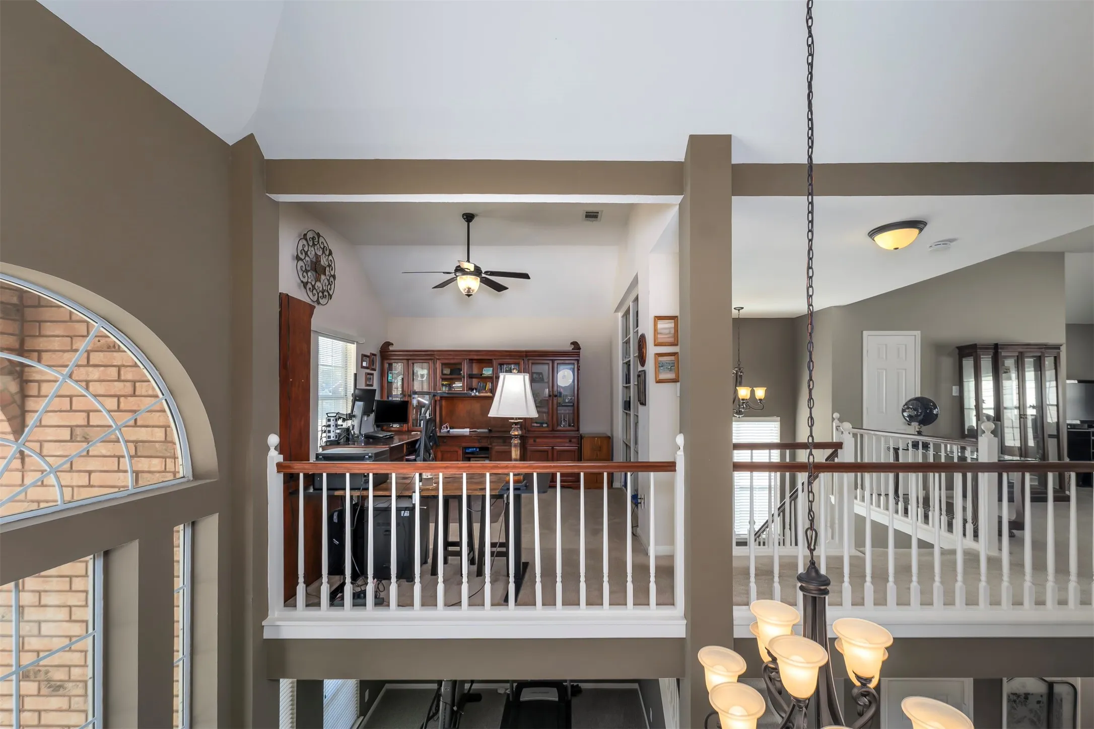 Hallway featuring vaulted ceiling and hanging lights
