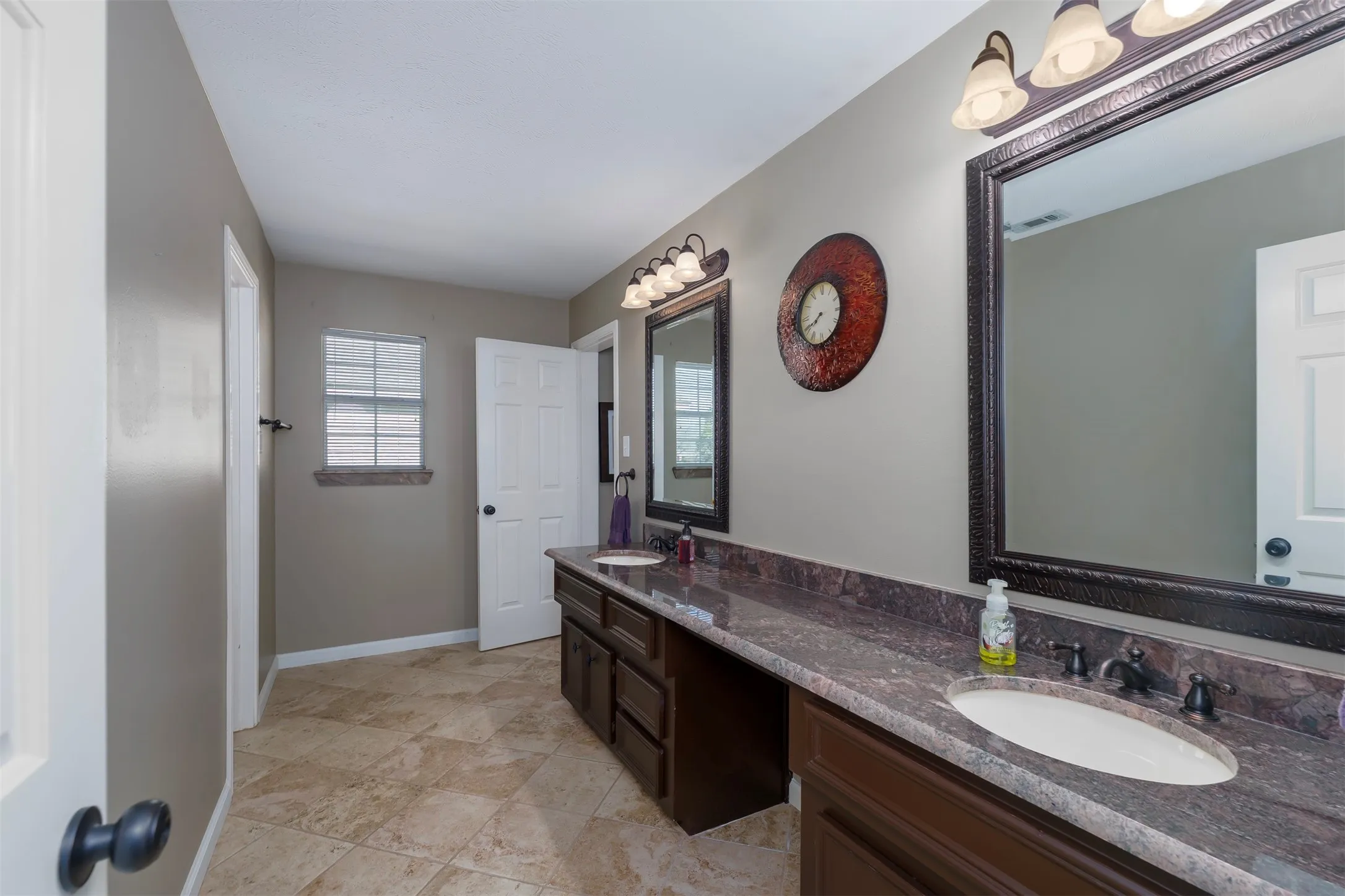 Bathroom featuring double vanity and baseboards