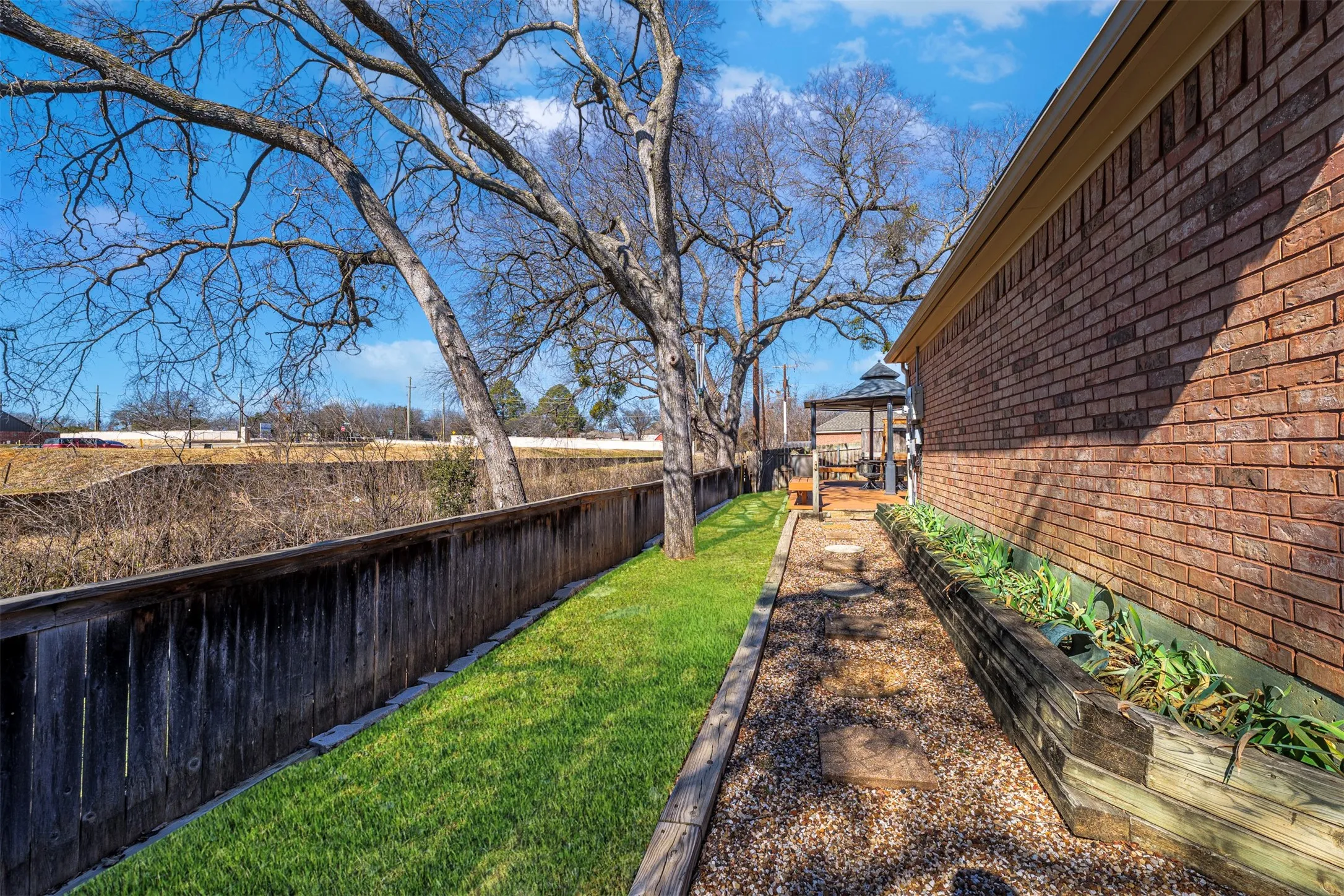 Fenced backyard with a gazebo, a garden, and a water view