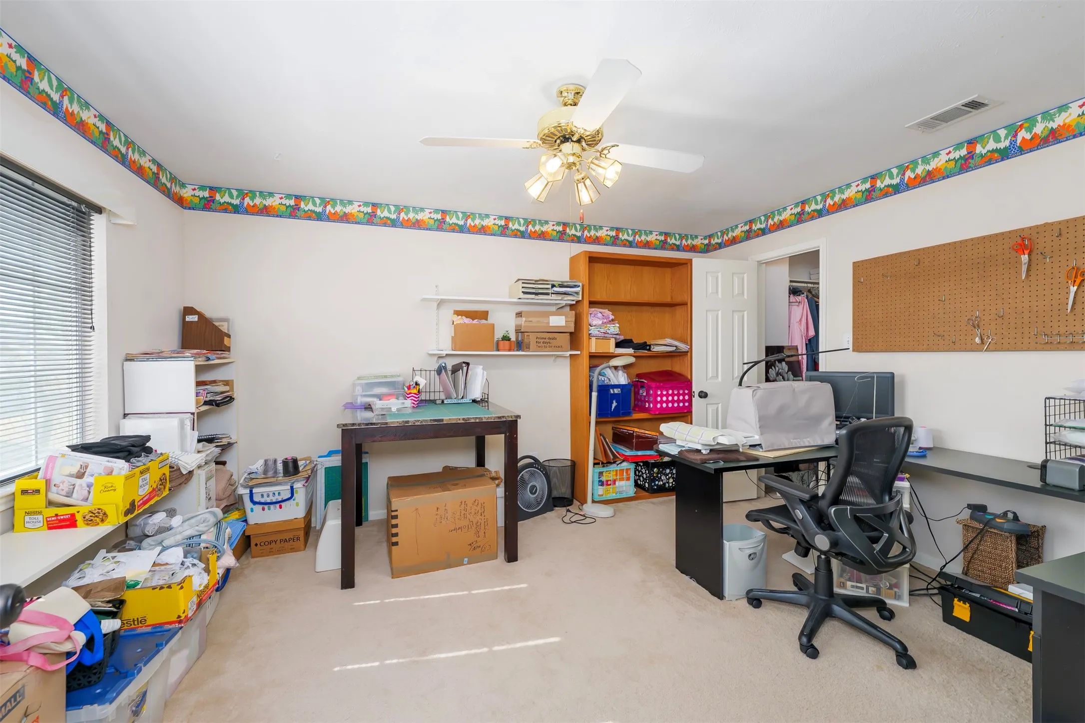 Office space with light carpet and ceiling fan