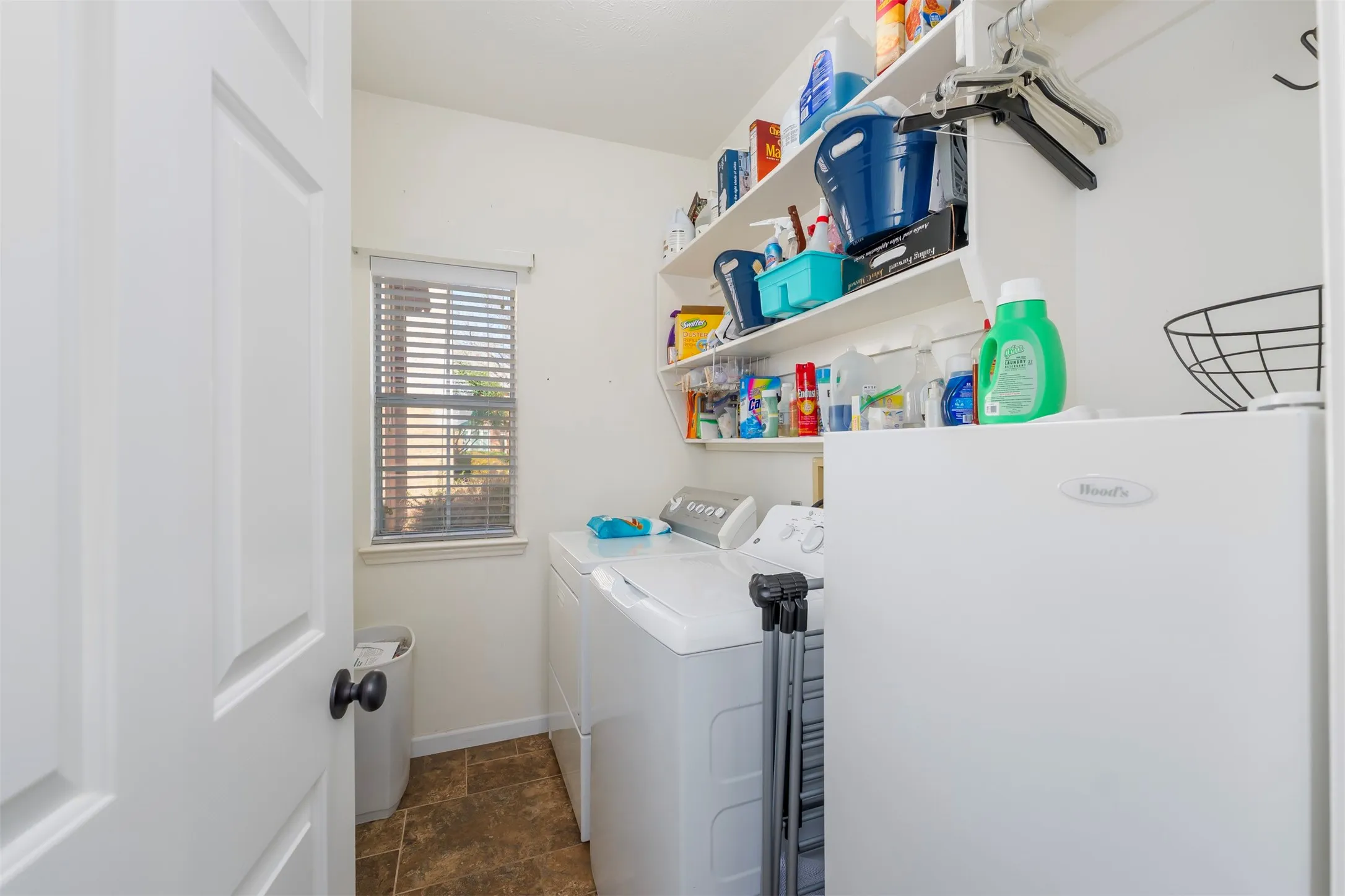 Laundry room featuring stone finish flooring and independent washer and dryer