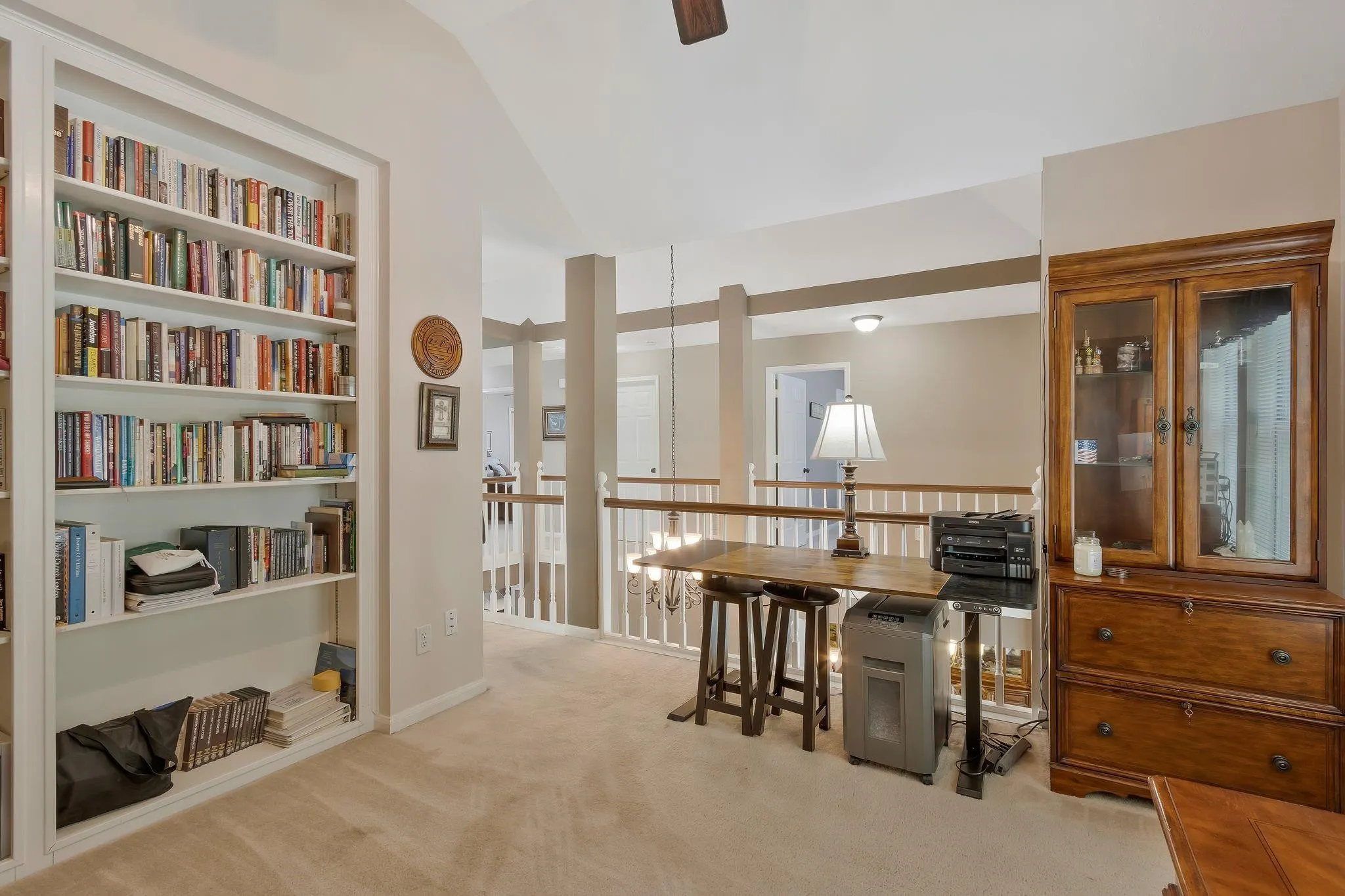 Office area with ceiling fan, light colored carpet, and lofted ceiling