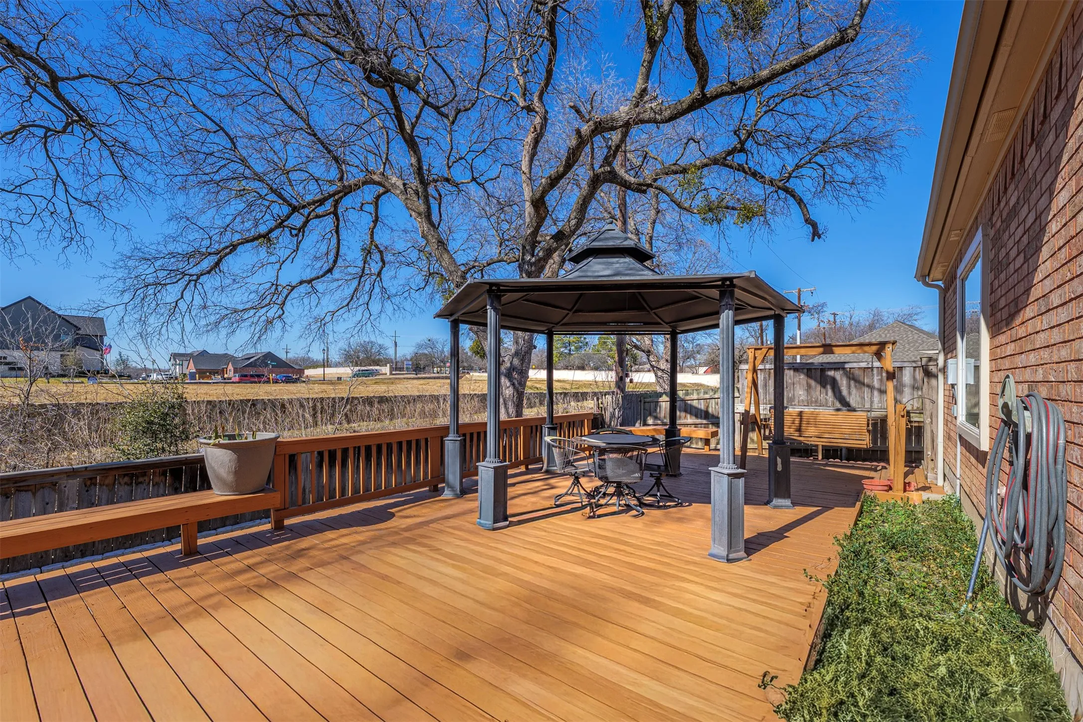 Wooden deck featuring a gazebo and a fenced backyard