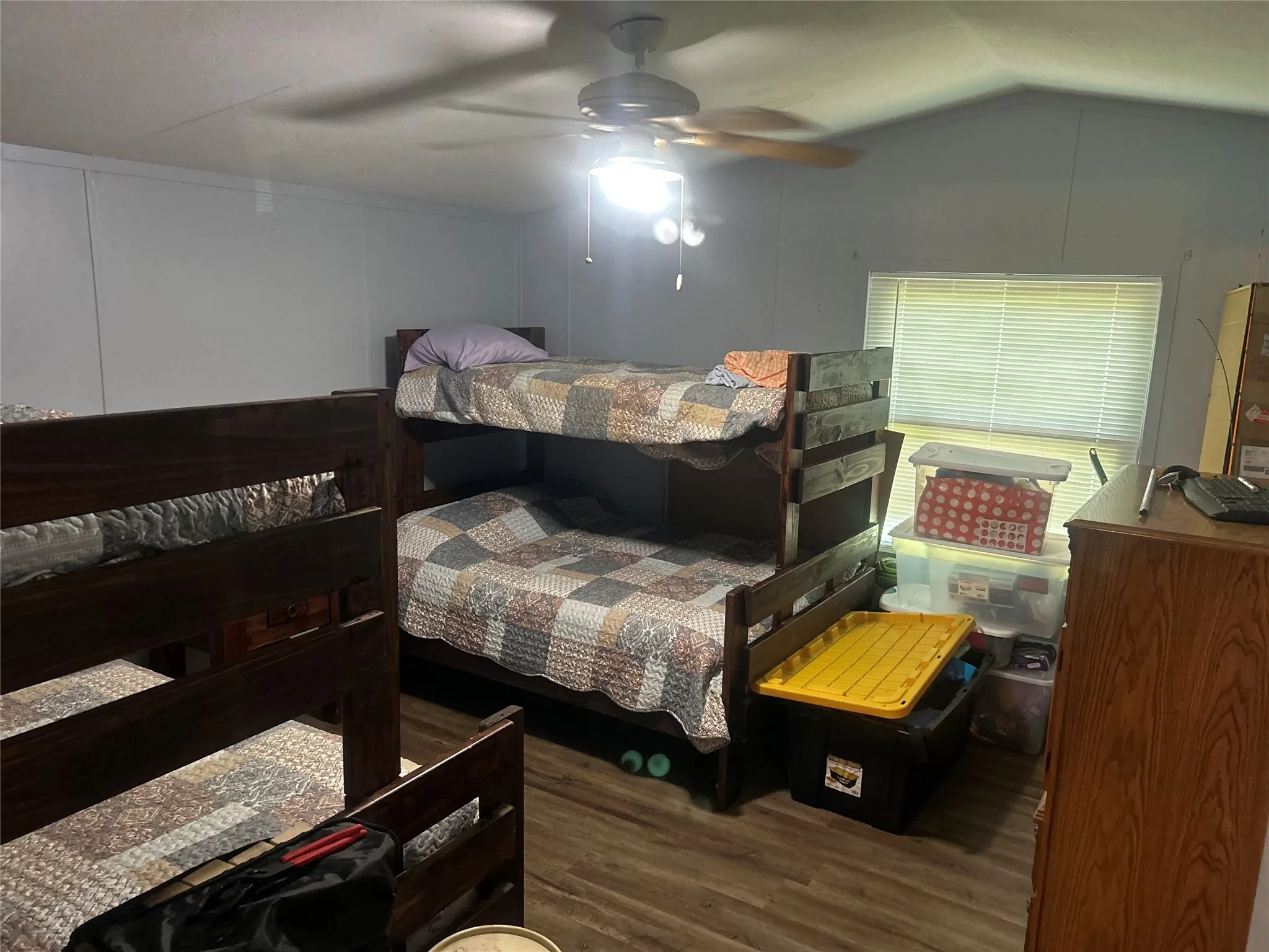 Bedroom featuring wood finished floors, vaulted ceiling, and ceiling fan