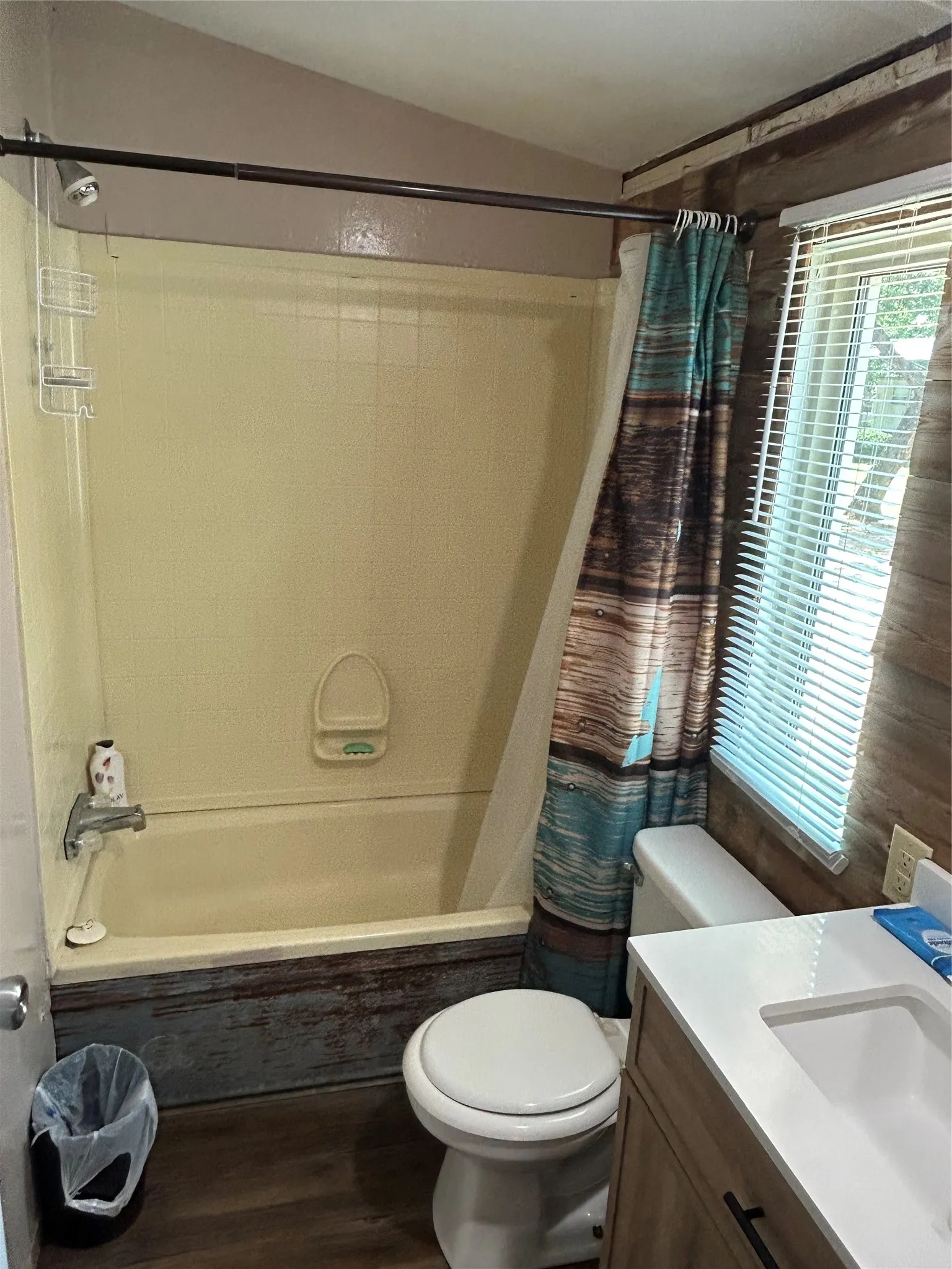 Full bathroom with shower / bath combo with shower curtain, wood finished floors, and vanity