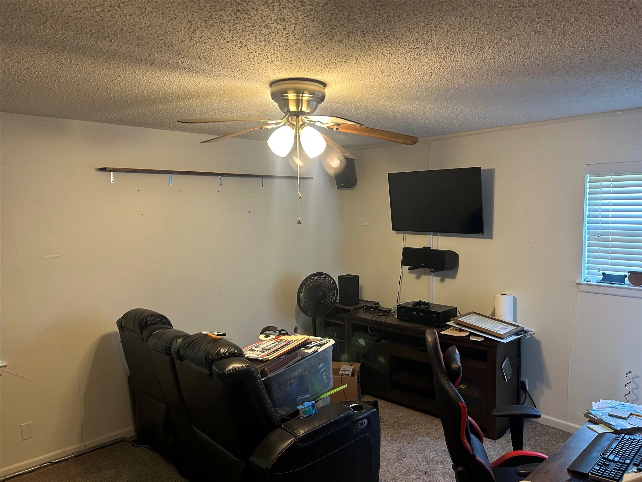 Office featuring a ceiling fan, carpet floors, a textured ceiling, and baseboards