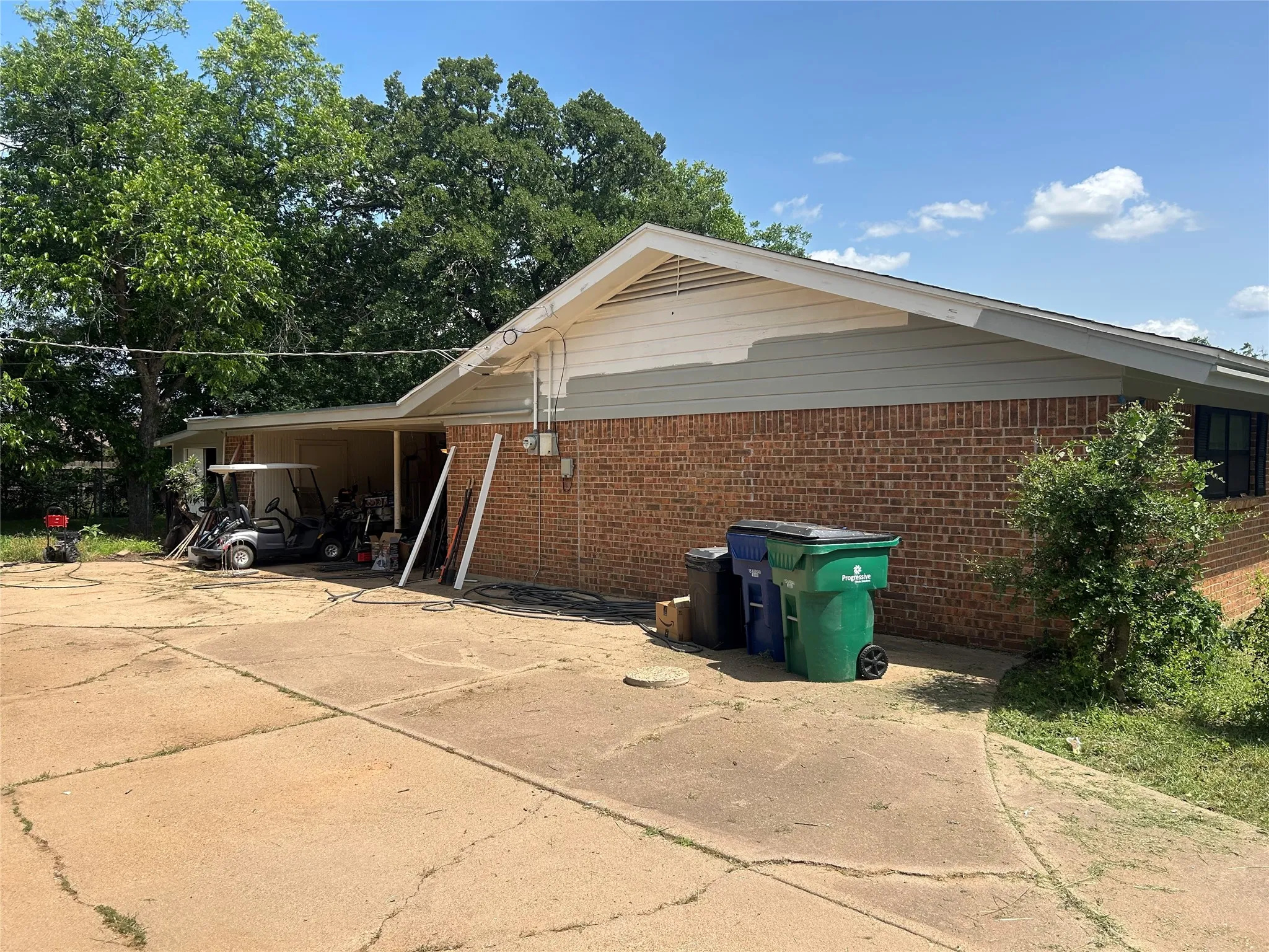 View of side of property featuring brick siding and a carport