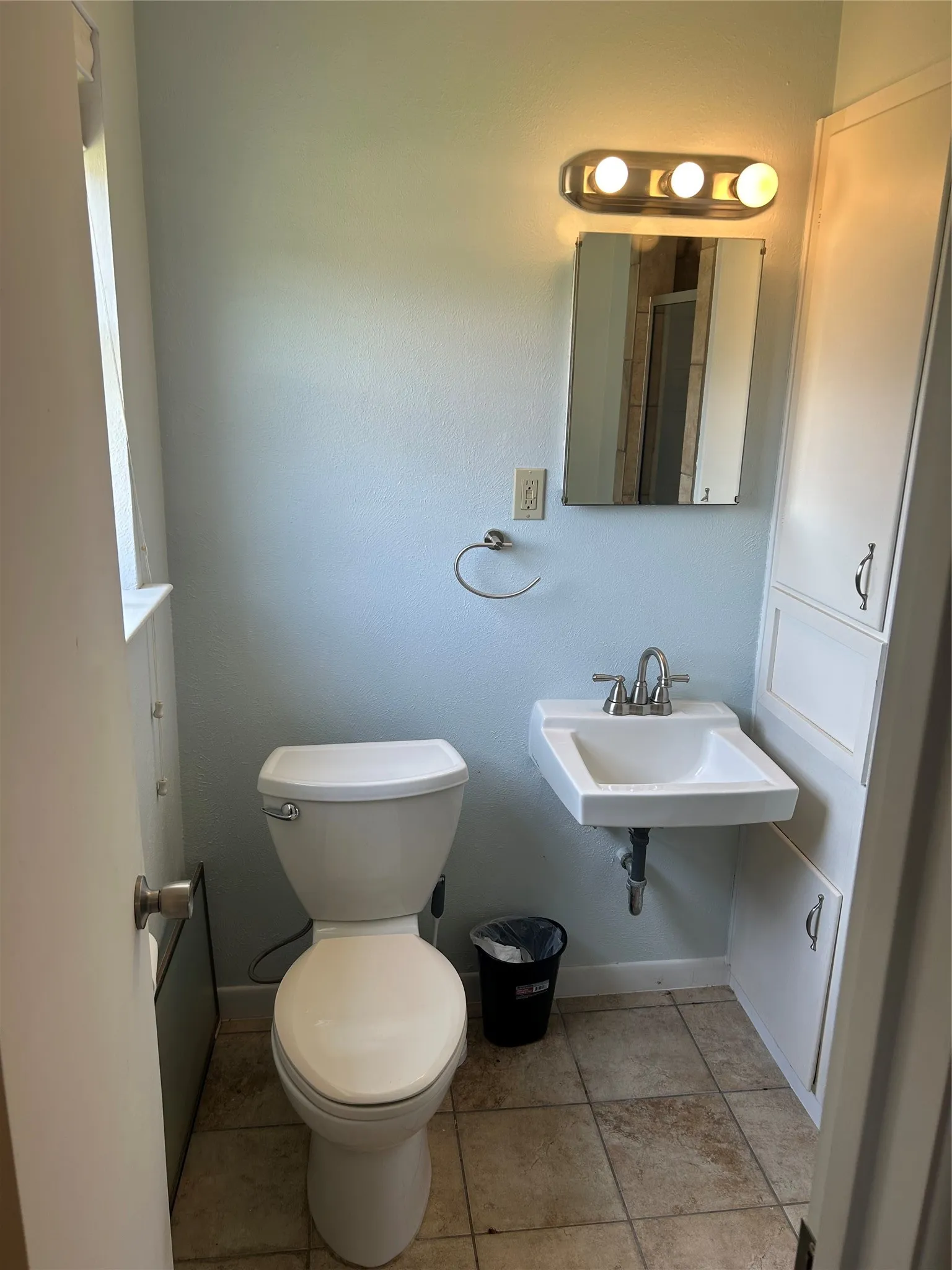 Bathroom featuring toilet, baseboards, and a sink