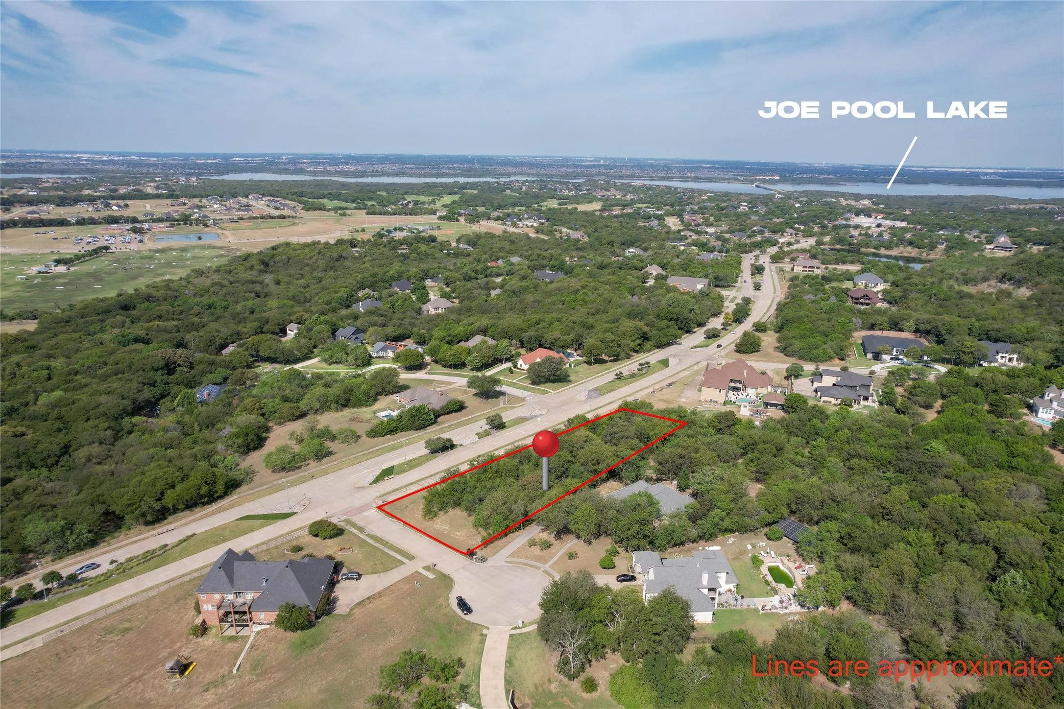 Aerial view of property and surrounding area with property parcel outlined and a nearby body of water