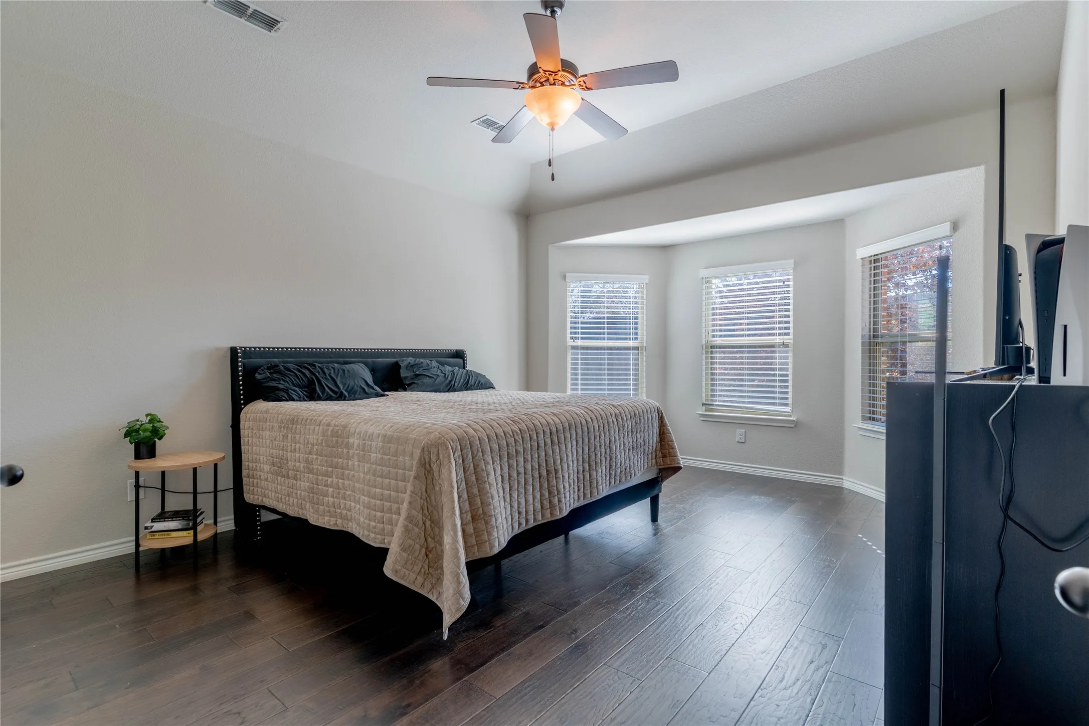 Bedroom with dark wood finished floors and ceiling fan