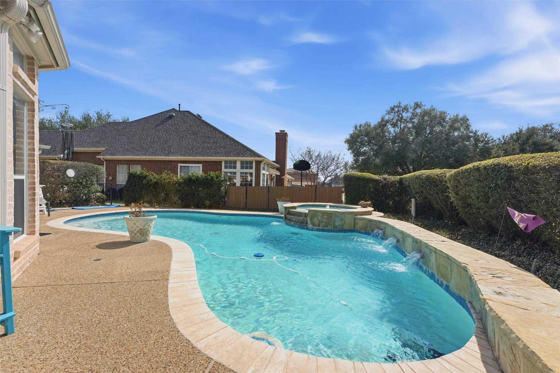 Relaxing pool / spa with a fenced backyard and a patio area