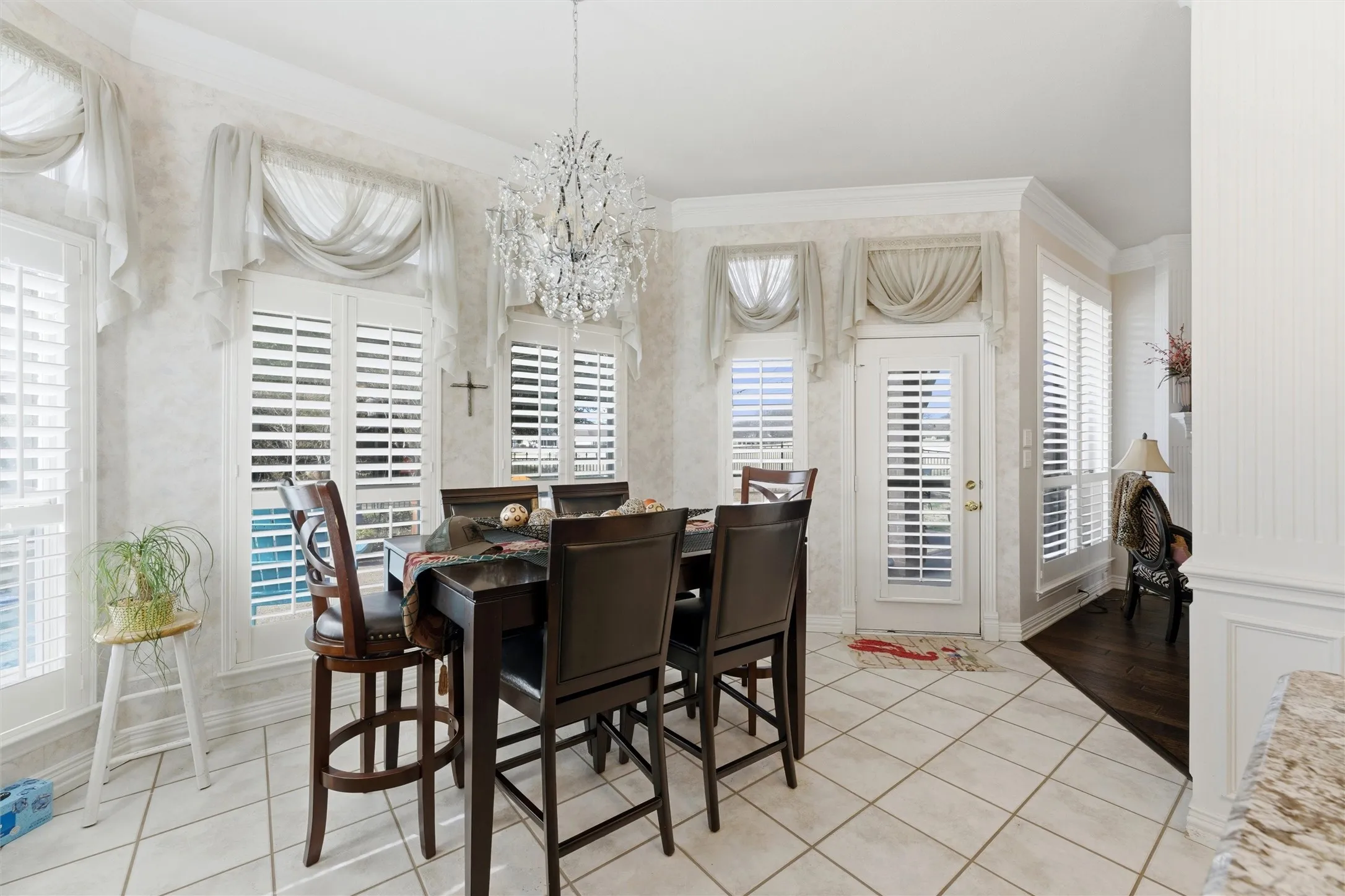 Dining room featuring a chandelier, light tile patterned floors, and crown molding