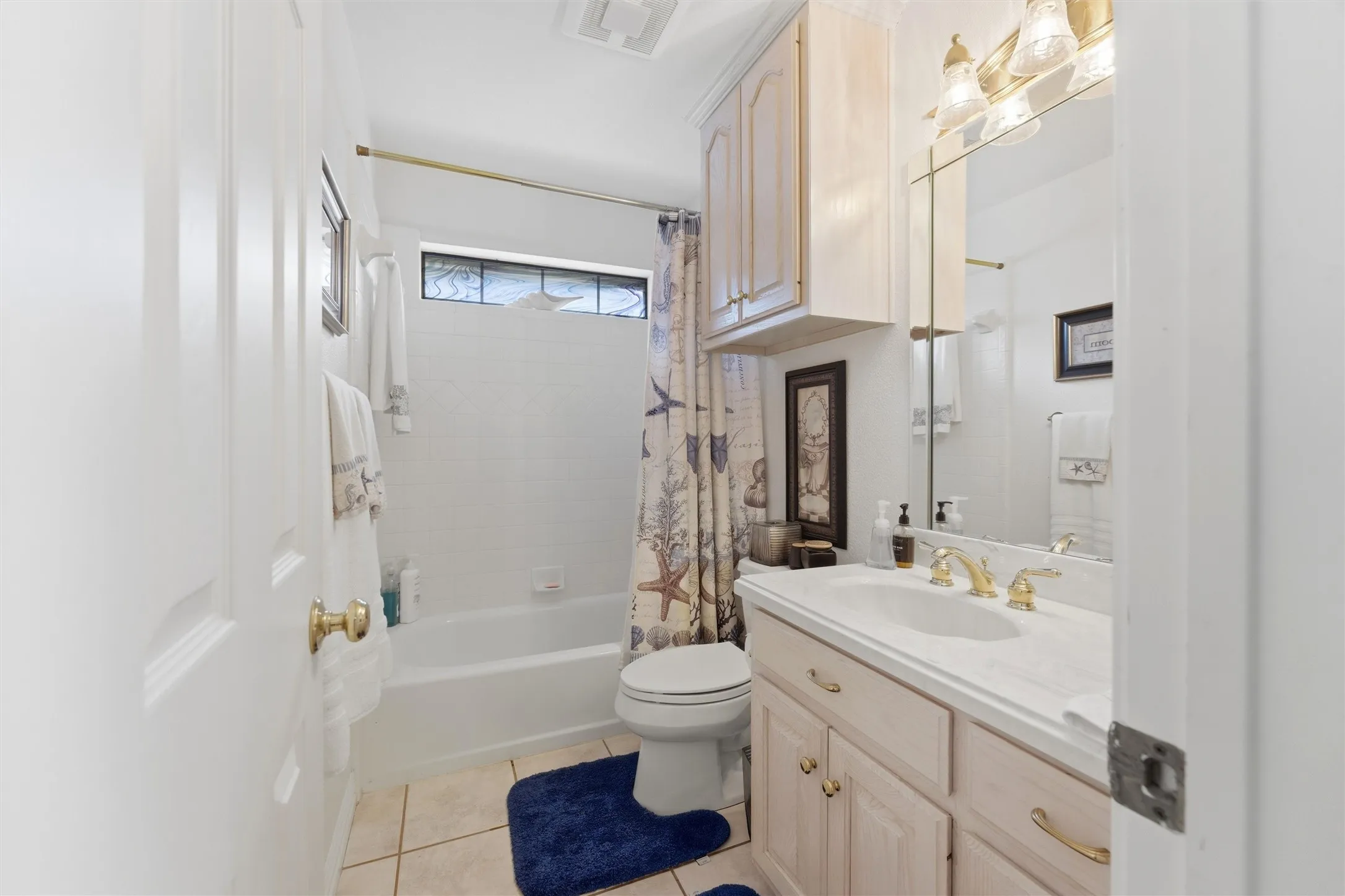 Full bath featuring vanity, shower / bath combination with curtain, and light tile patterned flooring