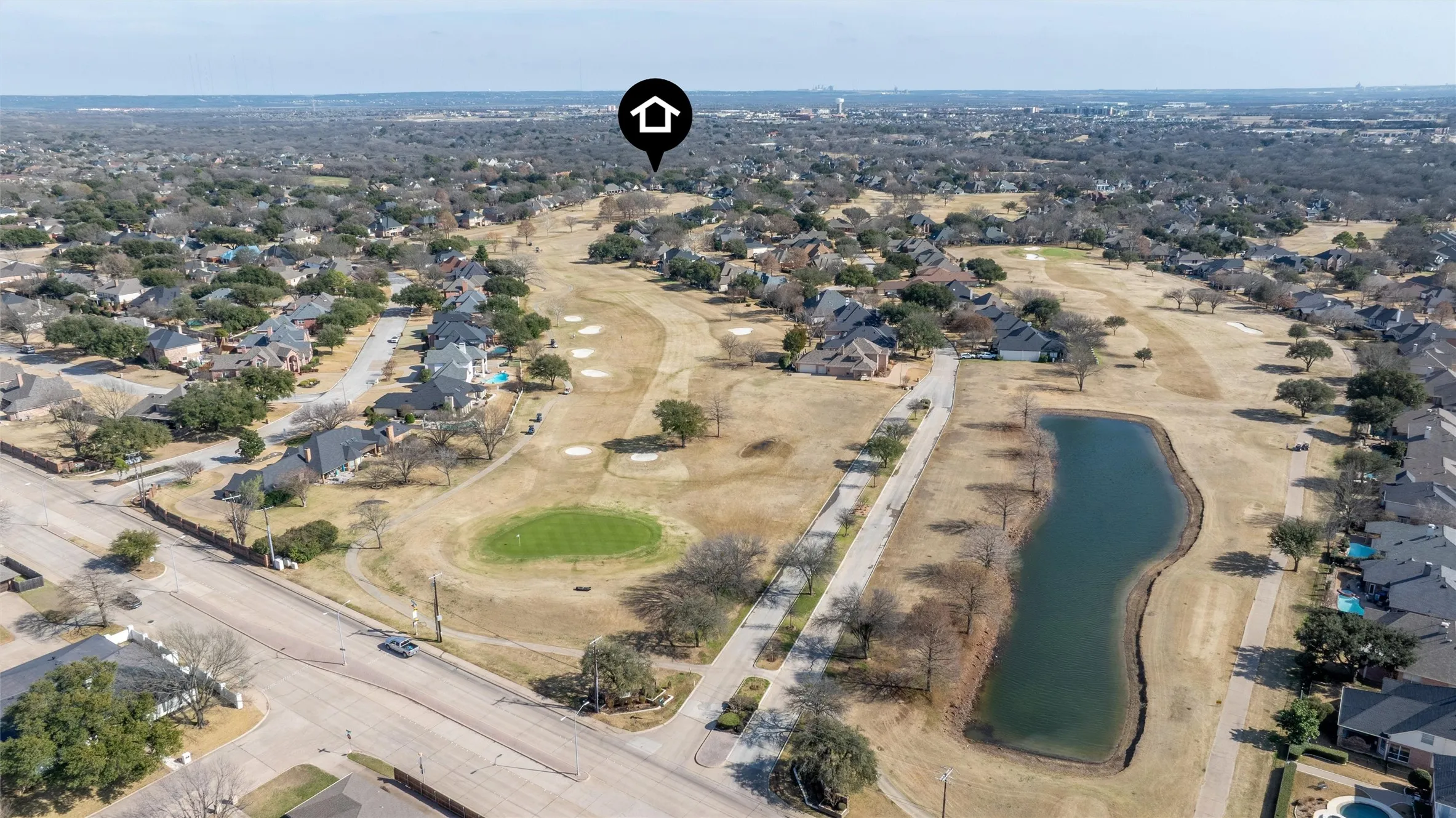 Aerial view of residential area with a large body of water and a local golf course
