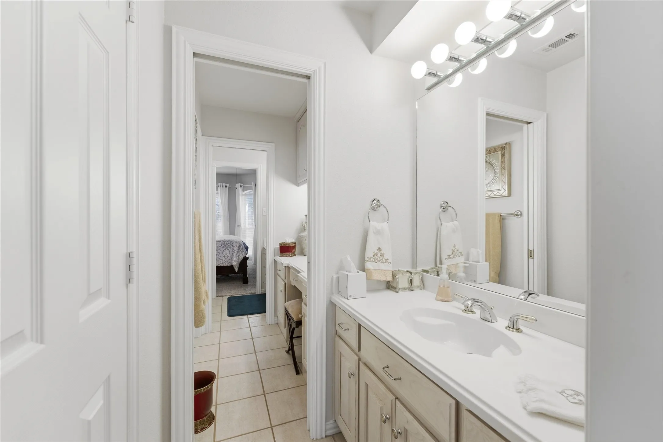 Bathroom featuring vanity, light tile patterned floors, and ensuite bath