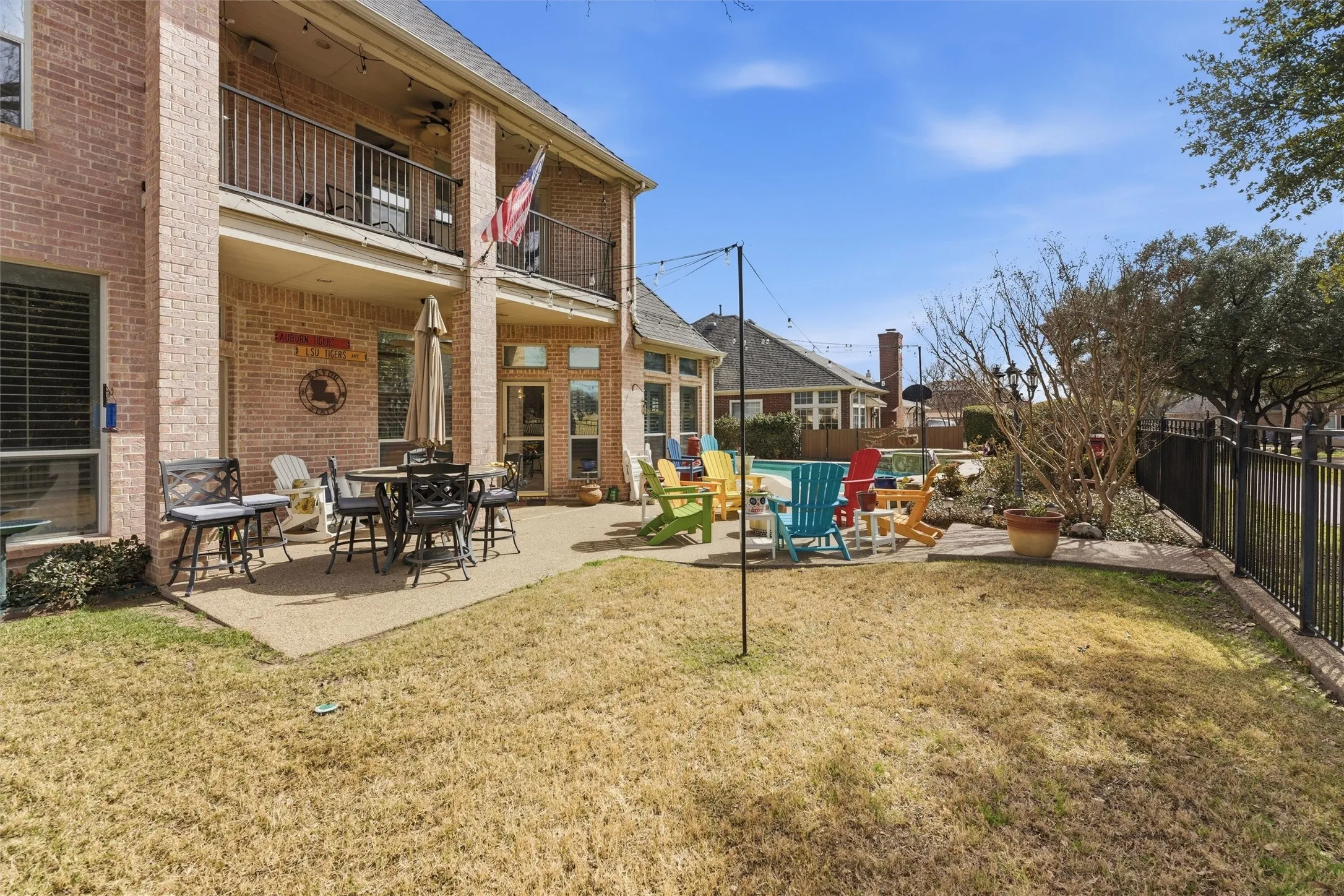 Fenced backyard featuring a patio, a balcony, and outdoor dining space