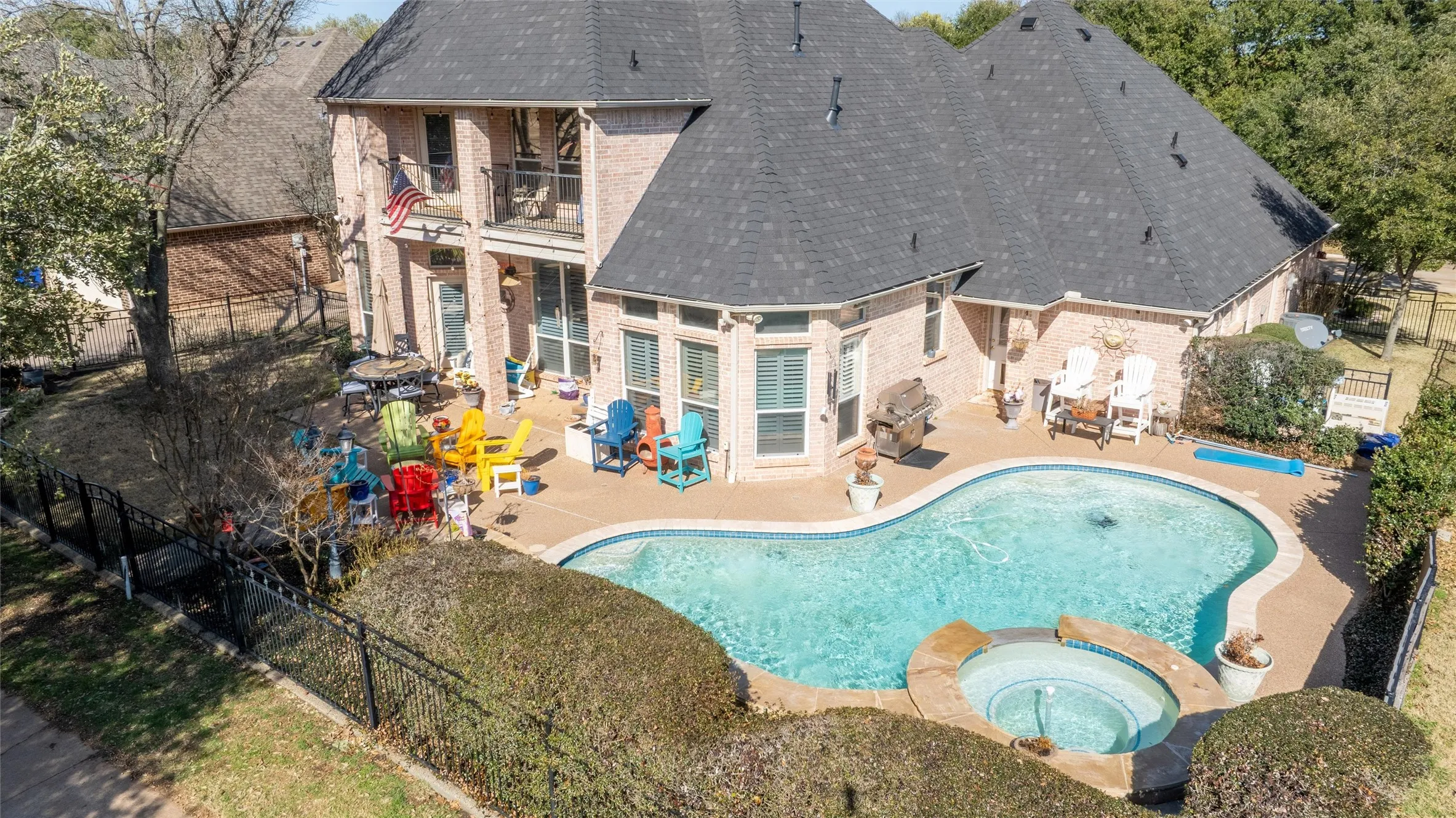 Rear view of property featuring a fenced backyard, a shingled roof, and a patio area