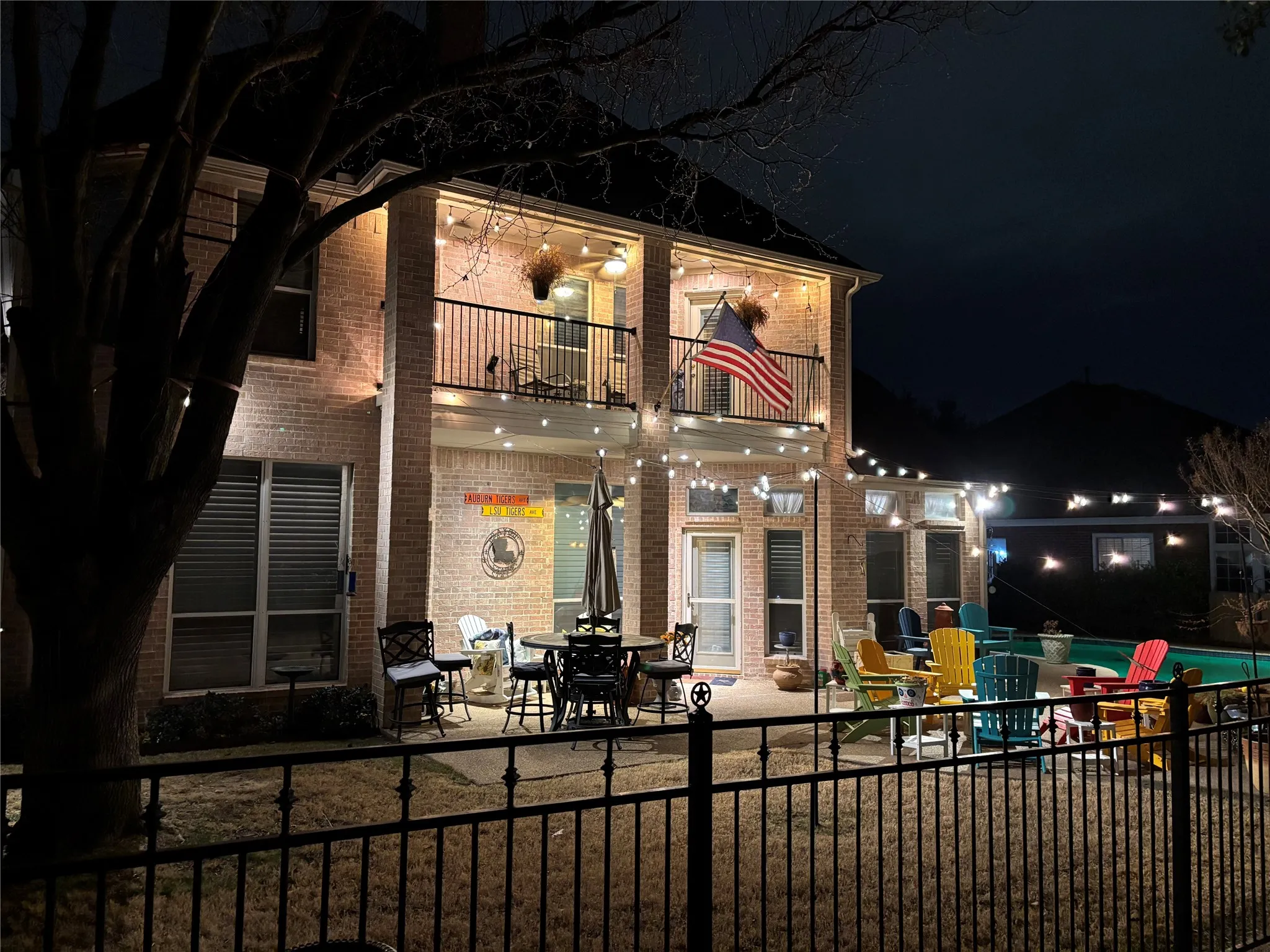 Back of house at twilight with a balcony, a patio area, brick siding, and outdoor dining area