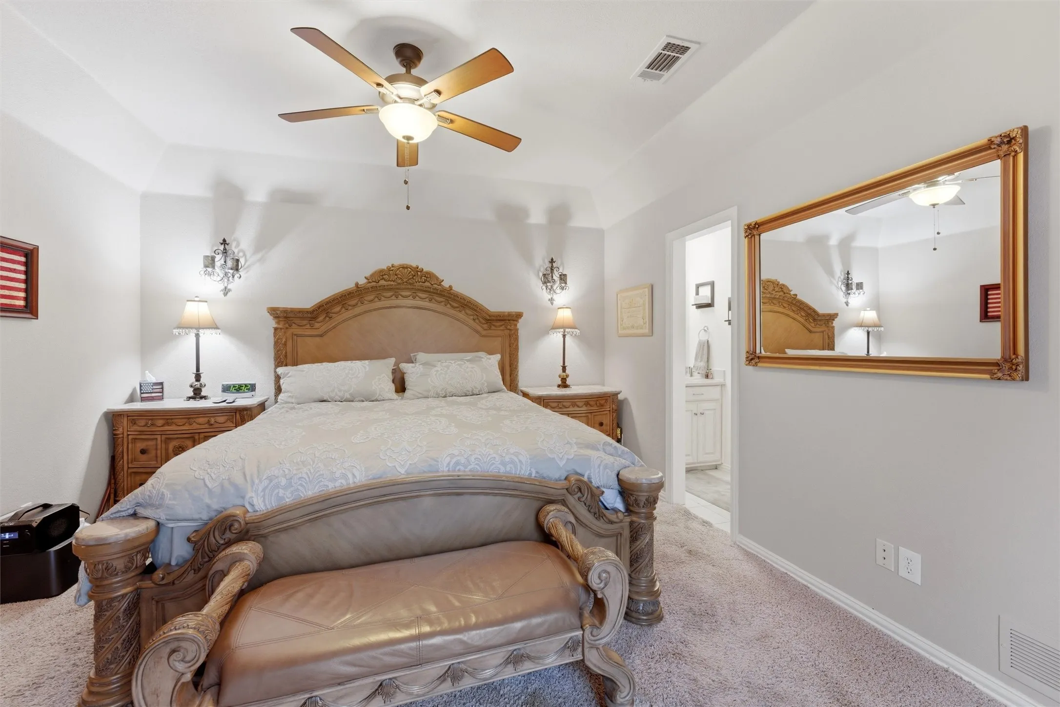 Bedroom featuring carpet, a ceiling fan, and ensuite bath