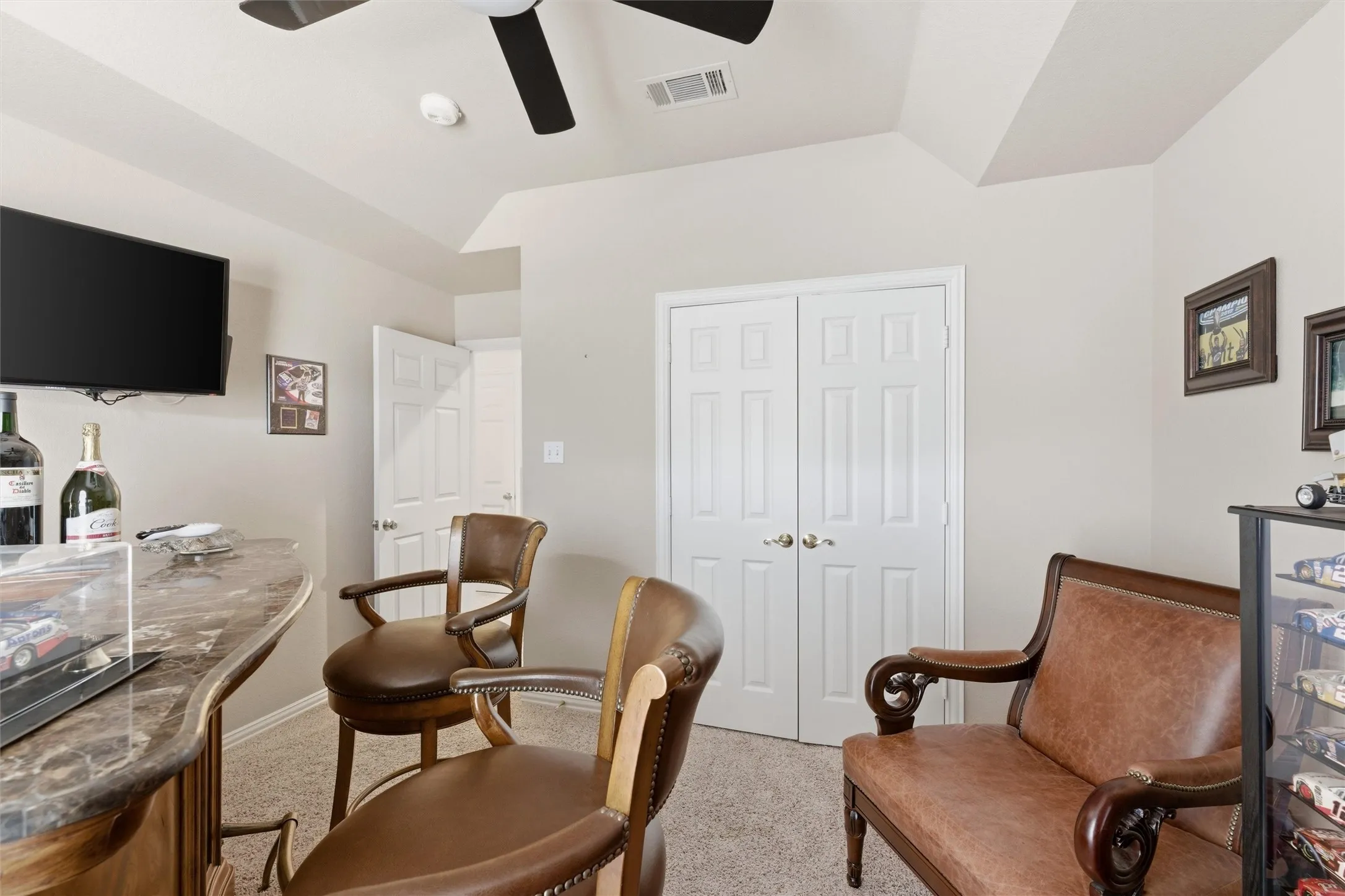 Sitting room featuring light carpet, lofted ceiling, and a ceiling fan