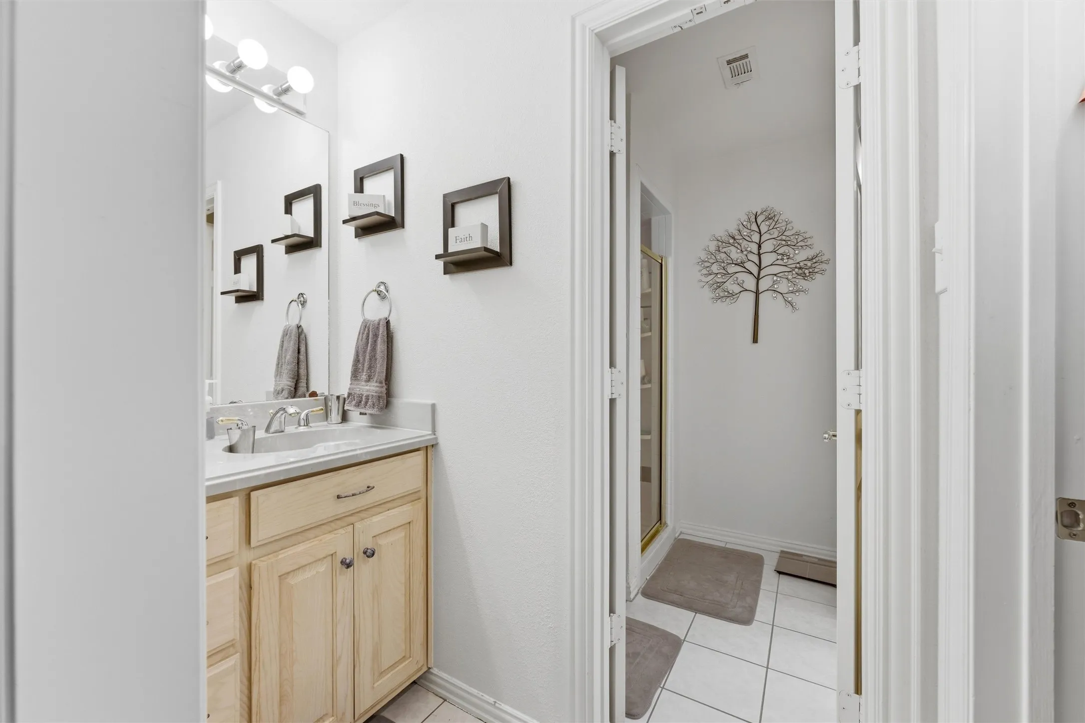 Bathroom with vanity, a shower stall, and light tile patterned floors
