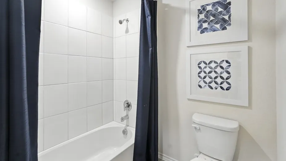 Bathroom with shower / bathtub combination with curtain and toilet