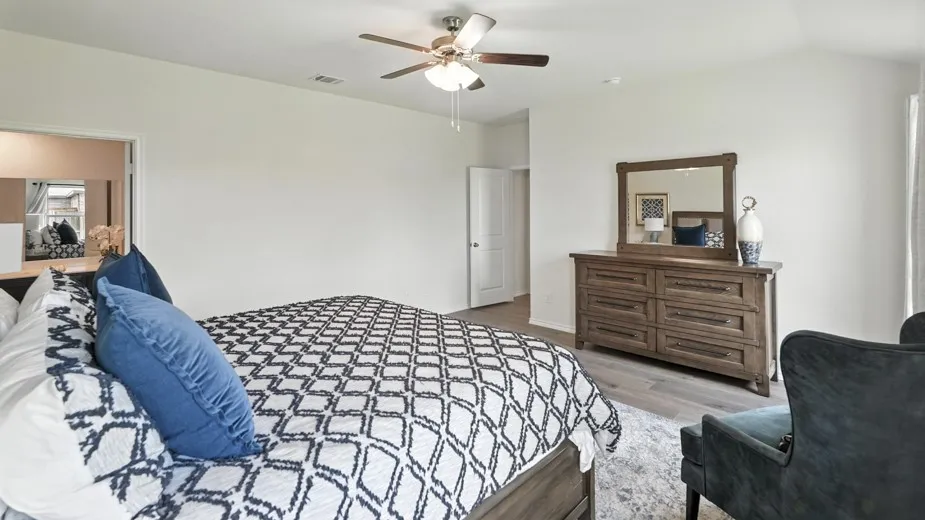 Bedroom with light wood-style floors, a ceiling fan, and vaulted ceiling