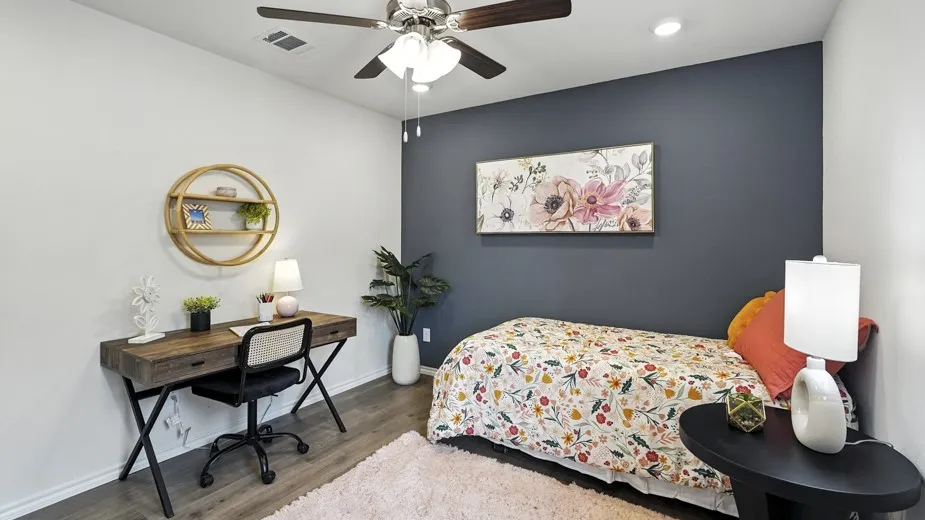 Bedroom with wood finished floors, a ceiling fan, an accent wall, recessed lighting, and an office area