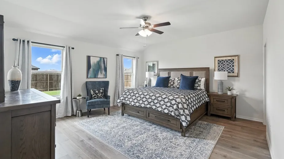 Bedroom with multiple windows, light wood-style flooring, and ceiling fan