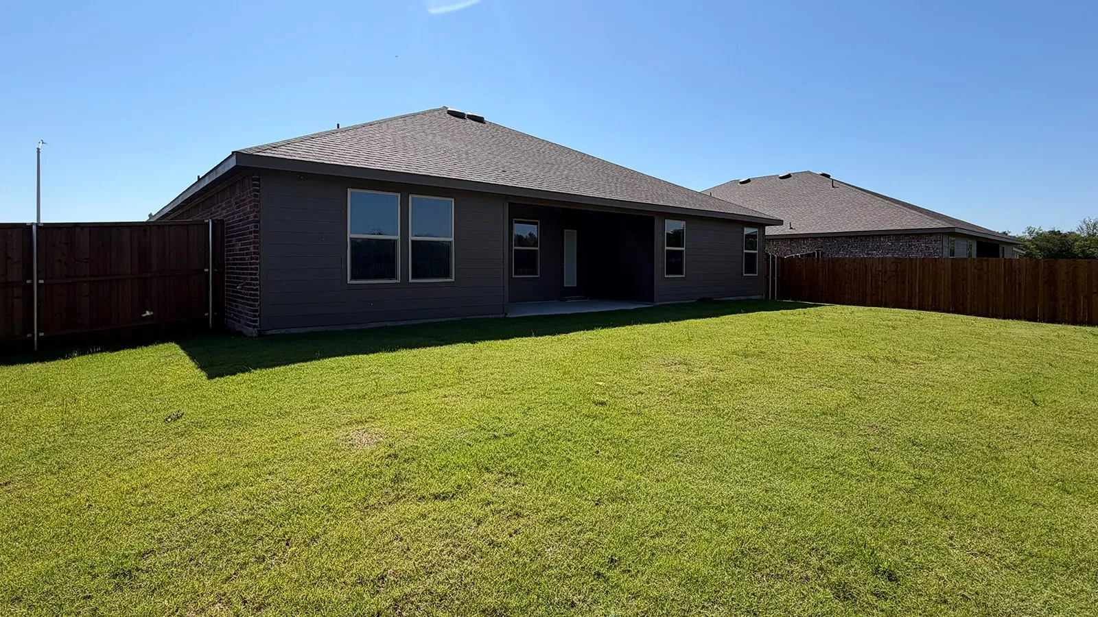 Expansive green lawn with a privacy fence