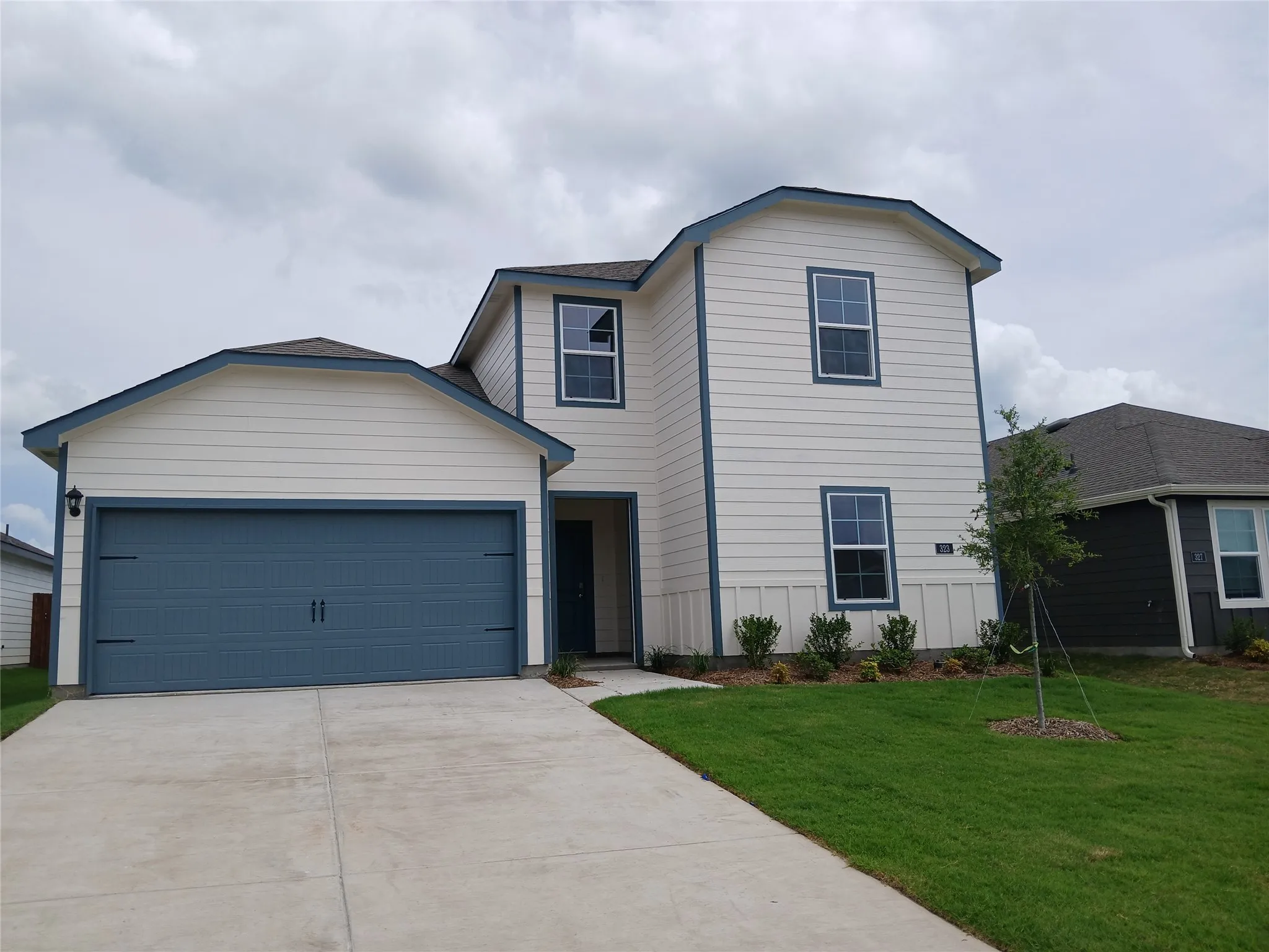 Two-story residence featuring light-colored siding with dark trim accents