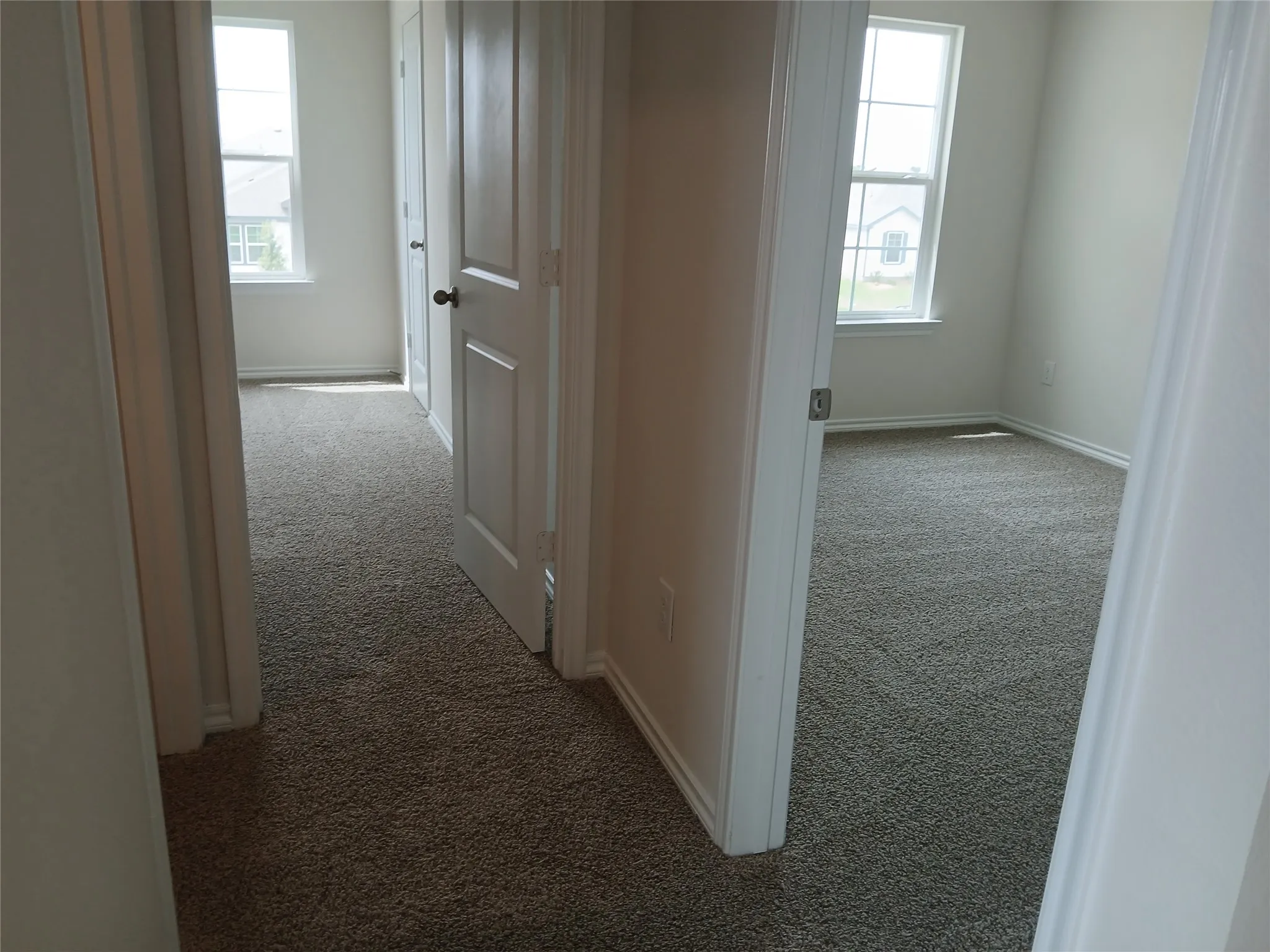 Neutral tone carpet flooring extends throughout multiple rooms