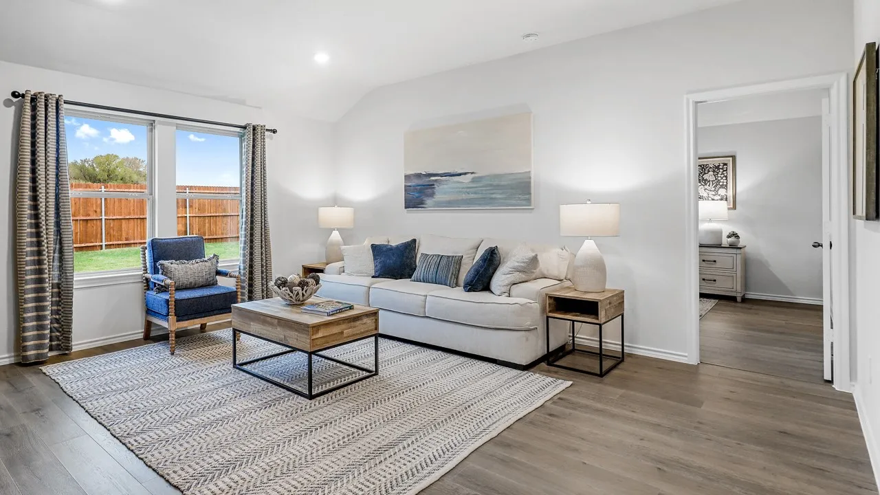 Bright living area featuring wood-finish flooring, white walls, and an open doorway